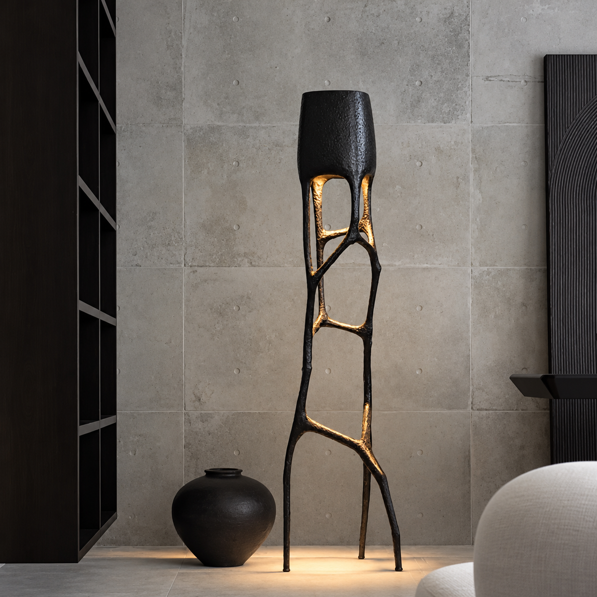 CL002 floor lamp beside a black vase against a stone wall, with all three feet visible.