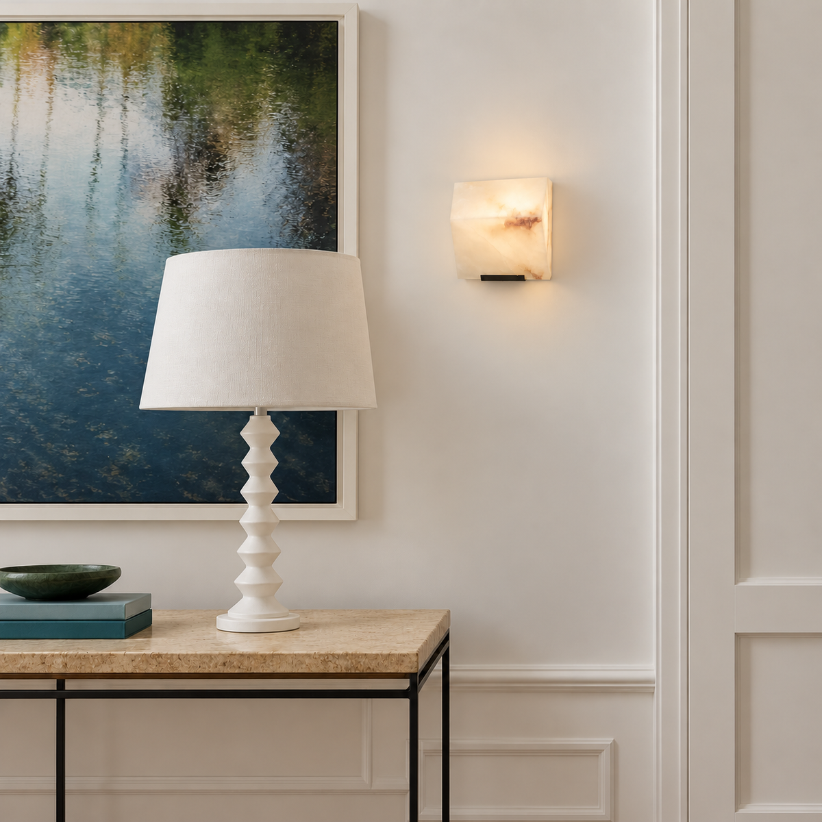 Single alabaster block sconce mounted beside artwork above a console.