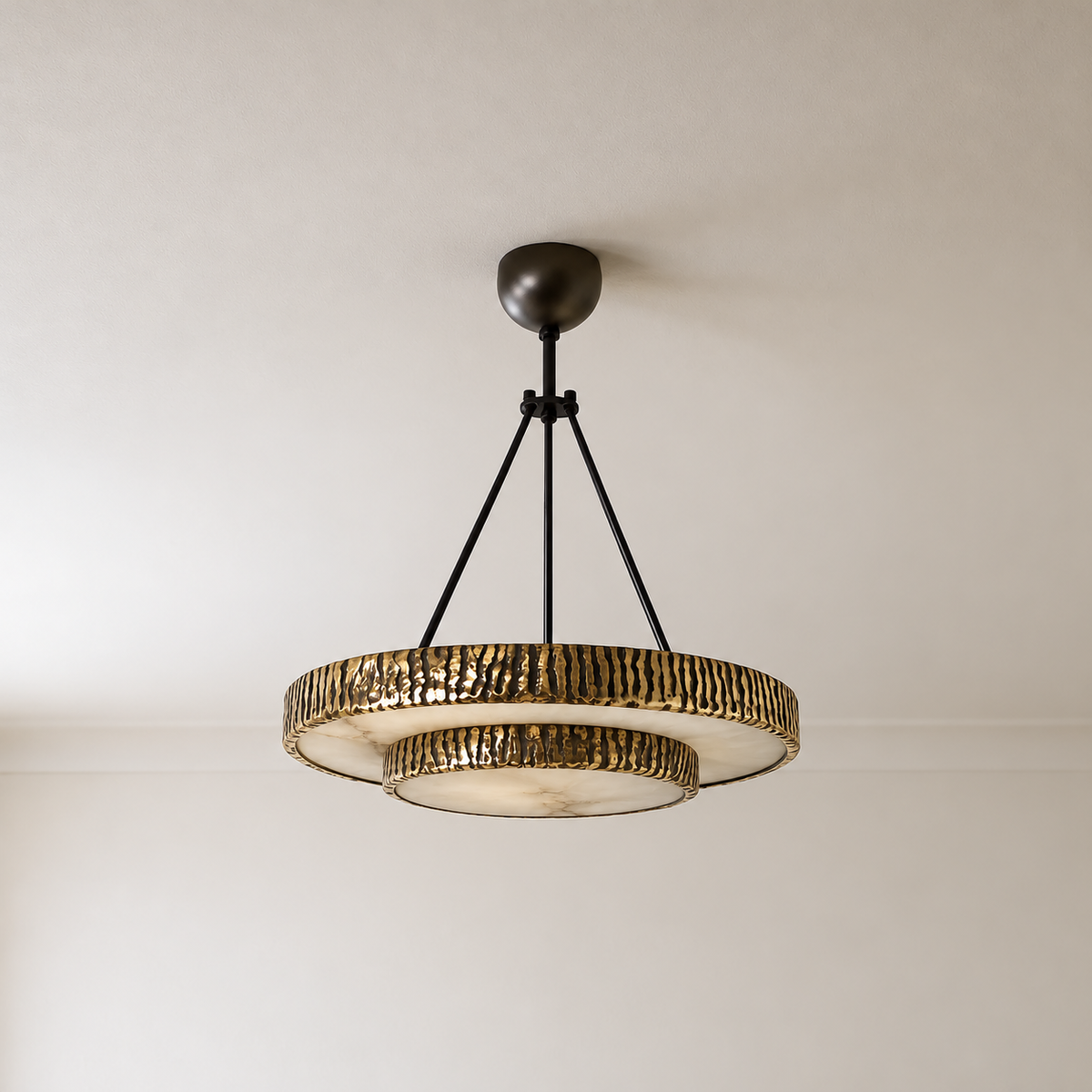 Unlit two-tier round alabaster chandelier with textured brass rims and dark support rods.