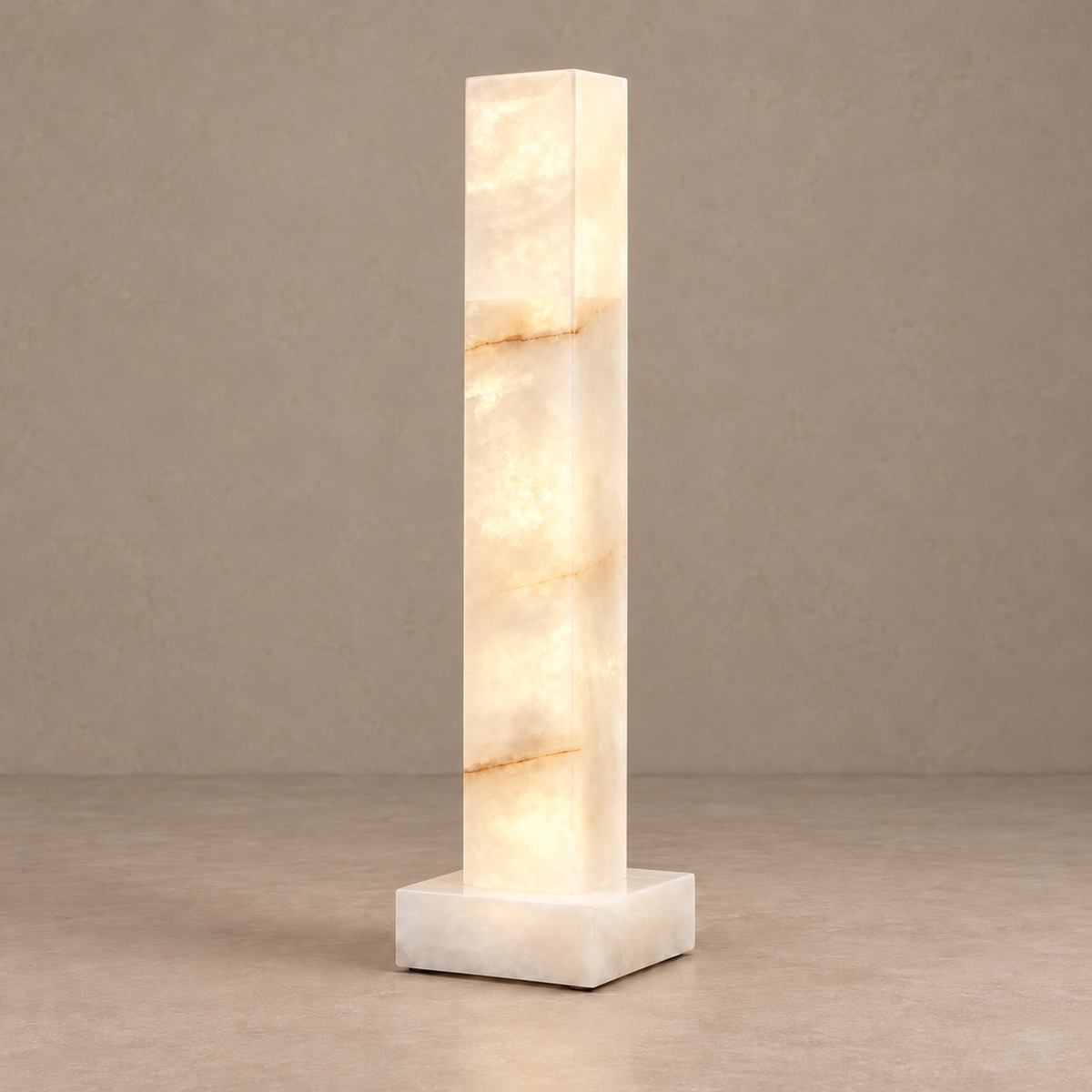 Small alabaster column lamp illuminated, showing its cloudy mineral pattern.