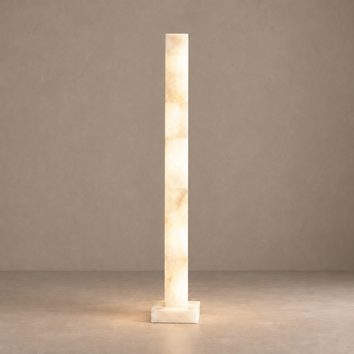 Large alabaster column floor lamp illuminated on its square base.