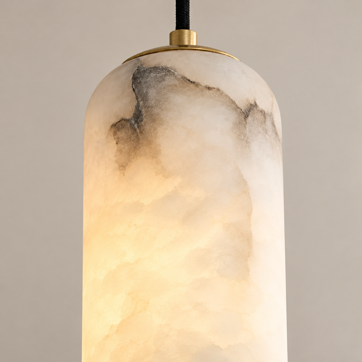 Natural grey mineral inclusions and cloudy alabaster at the pendant’s rounded top.