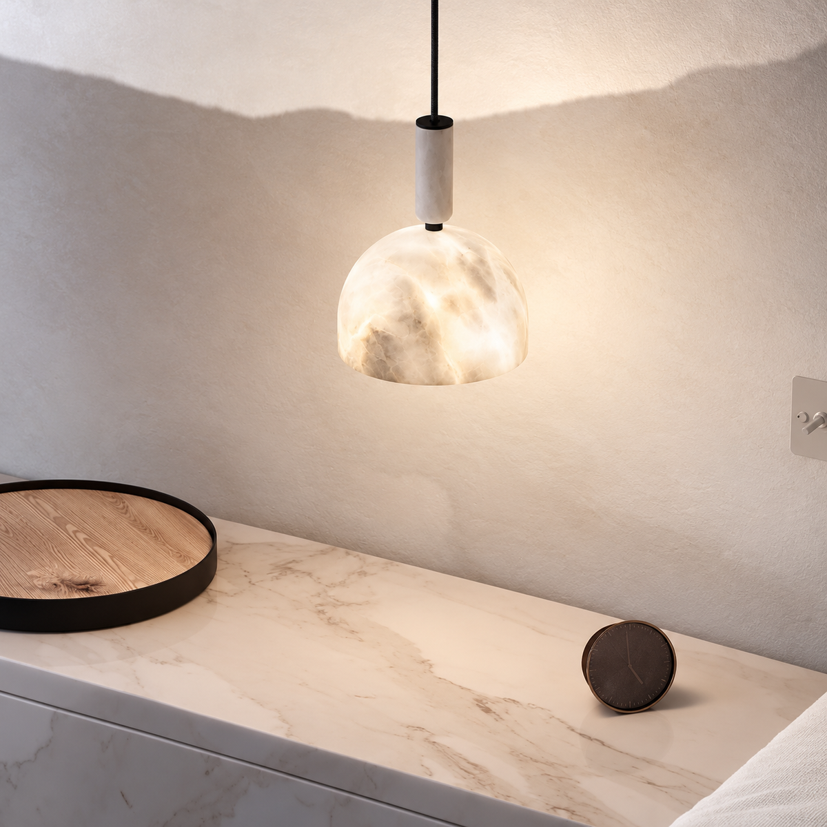 Alabaster dome pendant beside a bed above a marble-topped bedside cabinet.