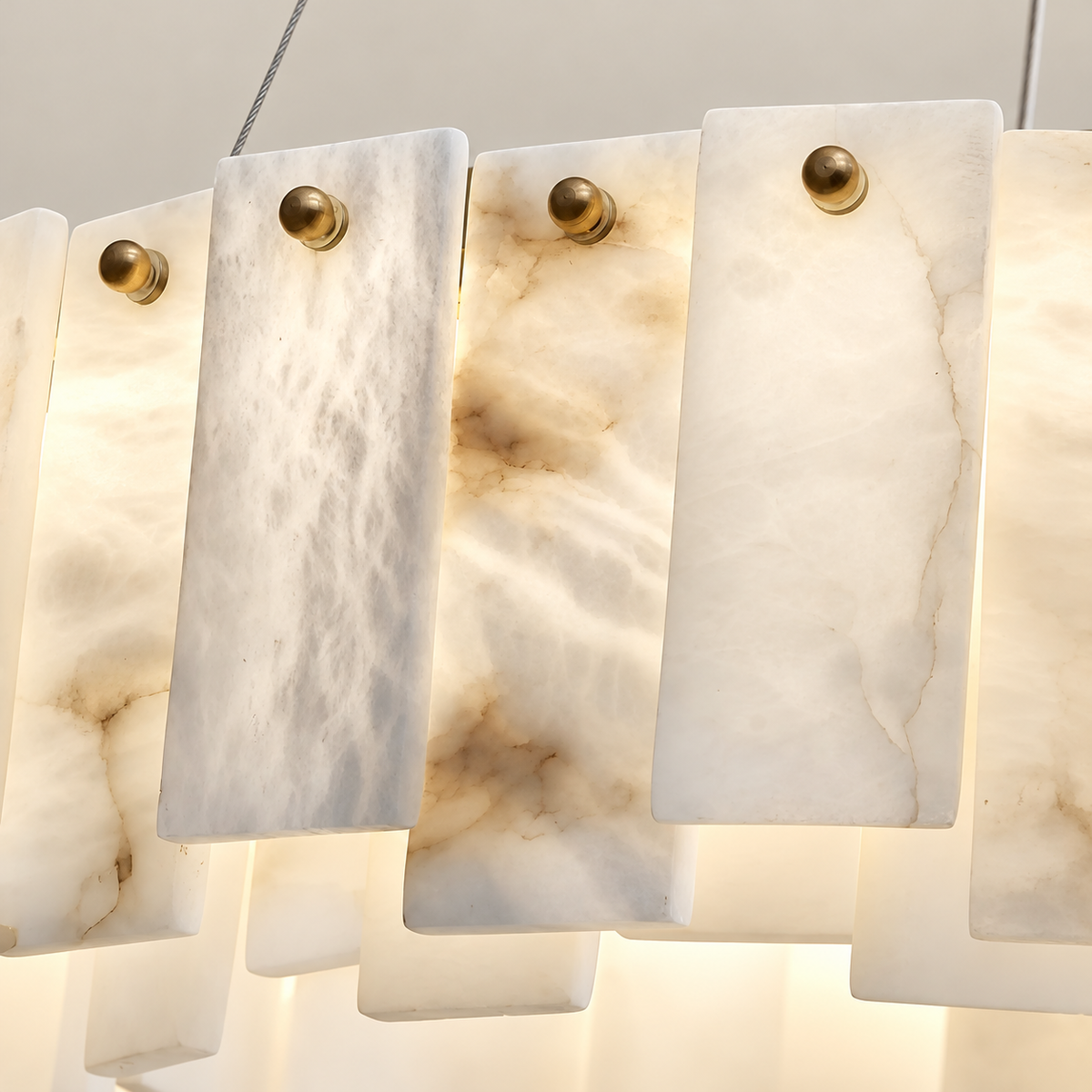 Close detail of clouded alabaster panels, natural veins and round brass pins.