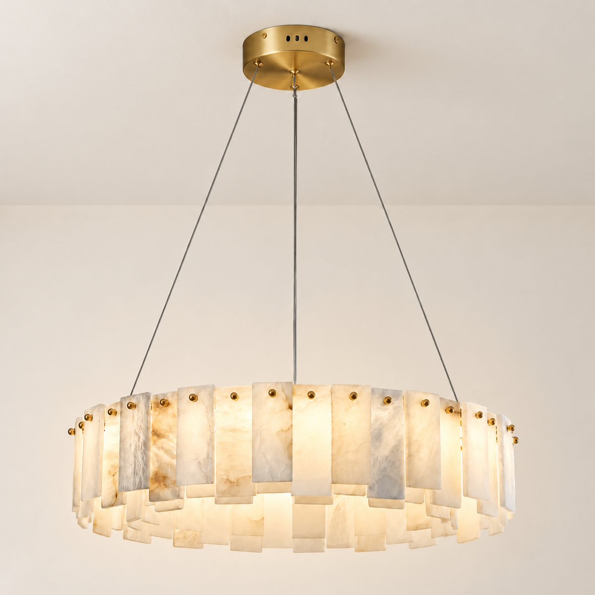 Illuminated alabaster ring chandelier with cloudy mineral layers and brass pins.