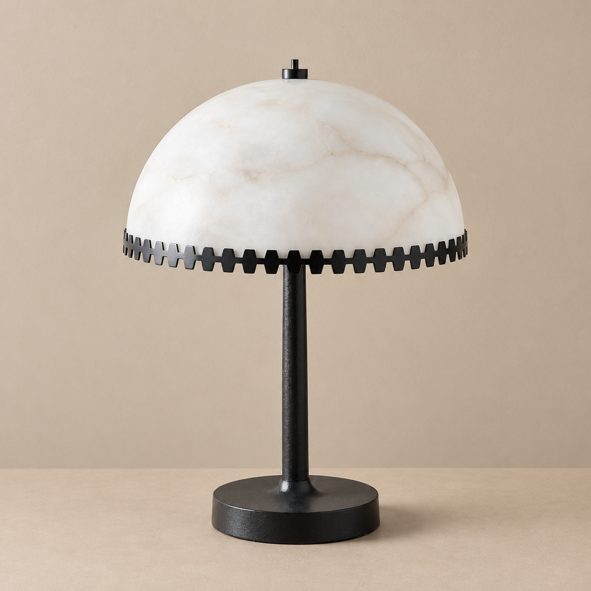 Alabaster dome table lamp with a black metal toothed rim, unlit on a beige background