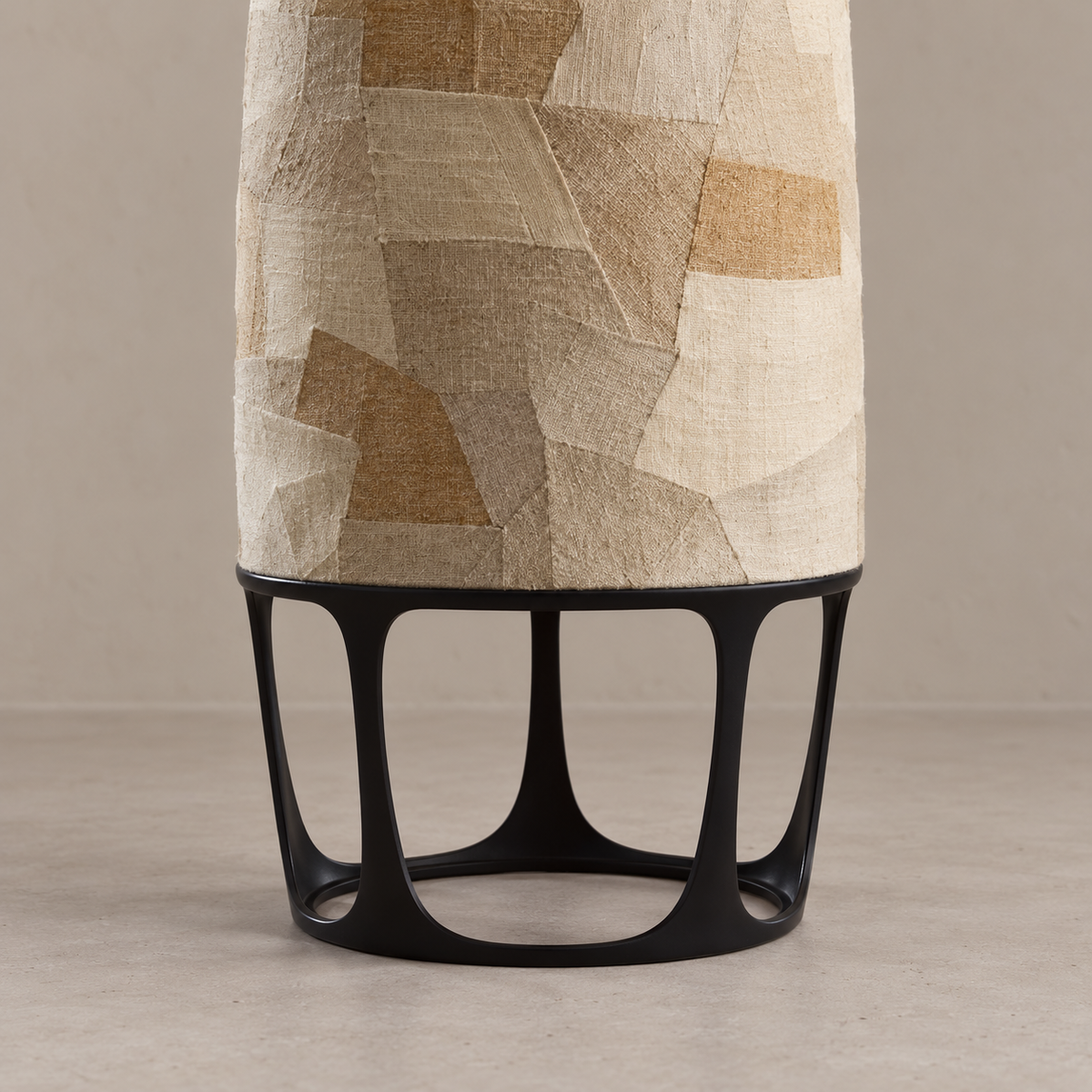 Appia floor lamp's black open metal base supporting the lower edge of its fabric column.