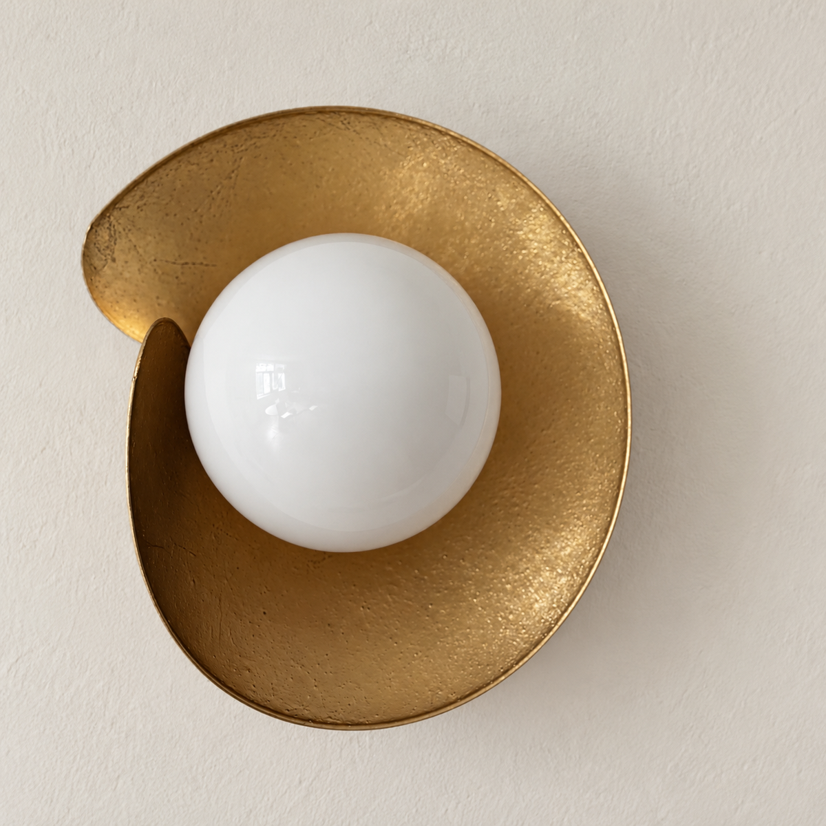Angled view of the folded brass shield and white glass globe.