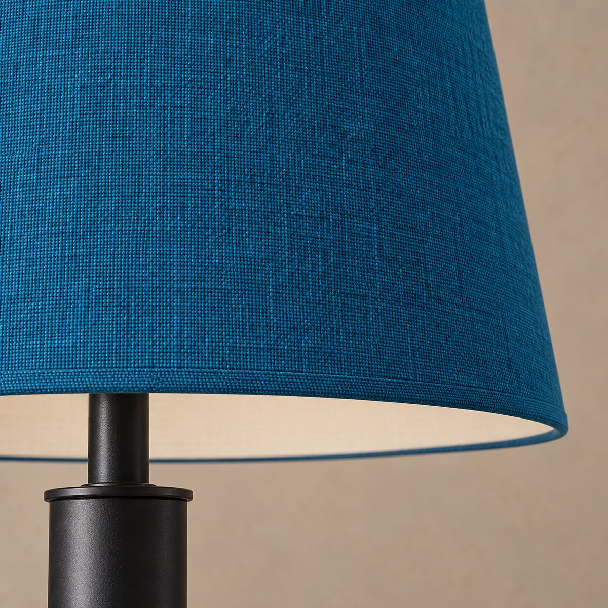 Close-up of the petrol blue shade's woven fabric and bound rim above the black stainless steel stem.