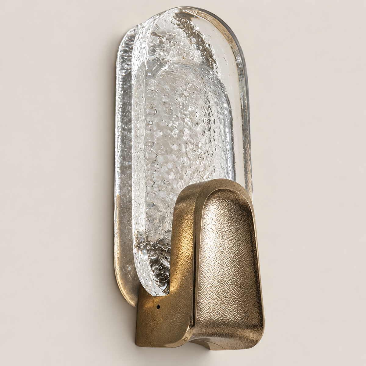 Close-up of the sconce's bubbled glass blade and textured brass base.