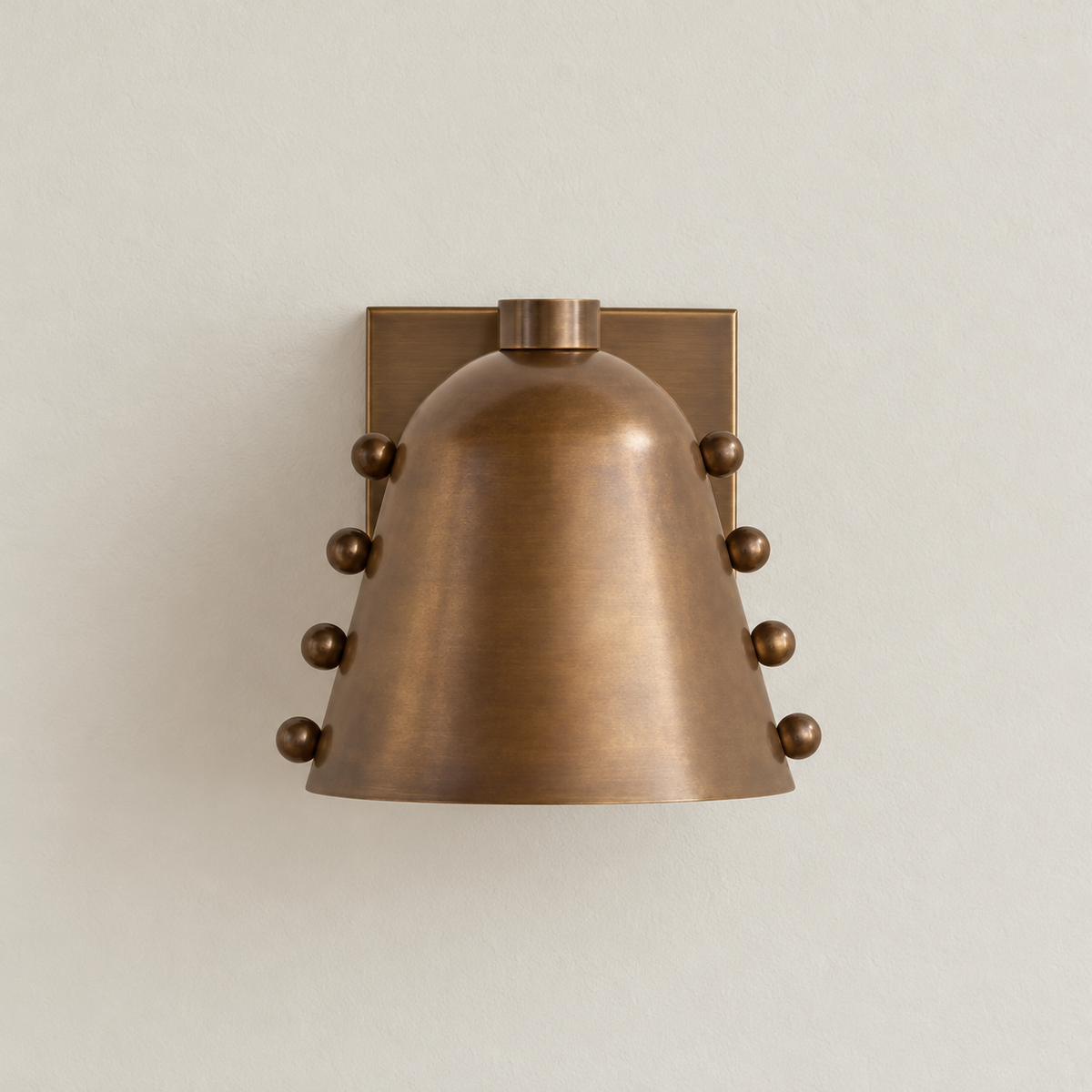 Antique brass cone wall sconce with ball studs, switched off.