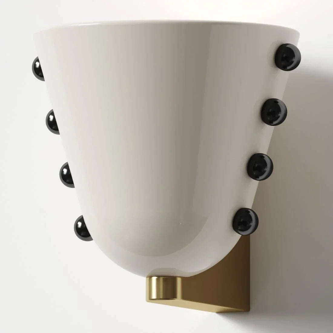 White glass cone wall sconce with dark studs on a brass mount