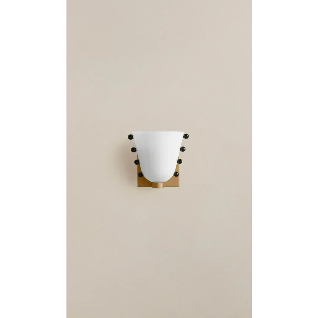 Small studded cone wall sconce on a pale wall