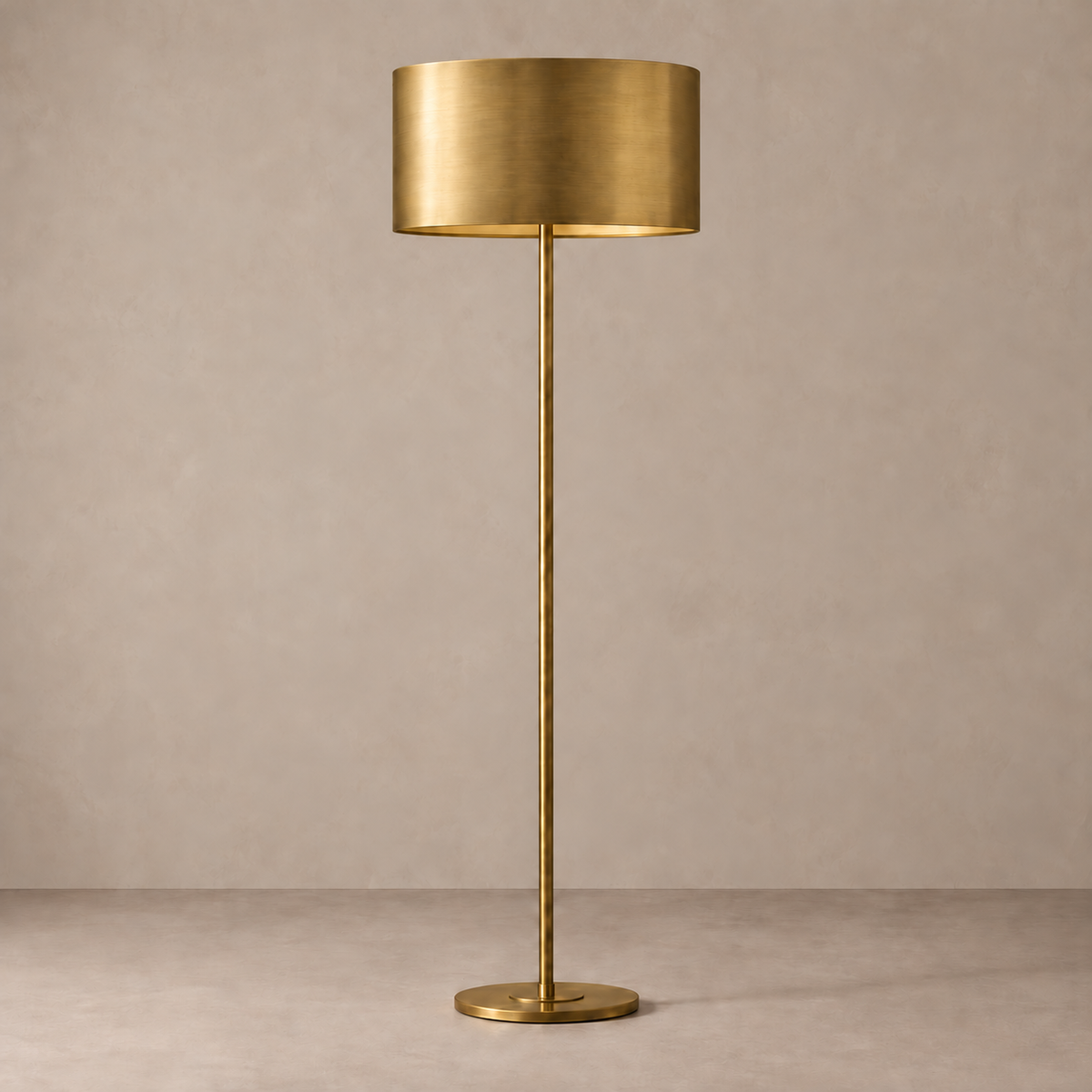 Brushed brass floor lamp with a 50 cm metal drum shade, shown unlit on a stone-beige background.