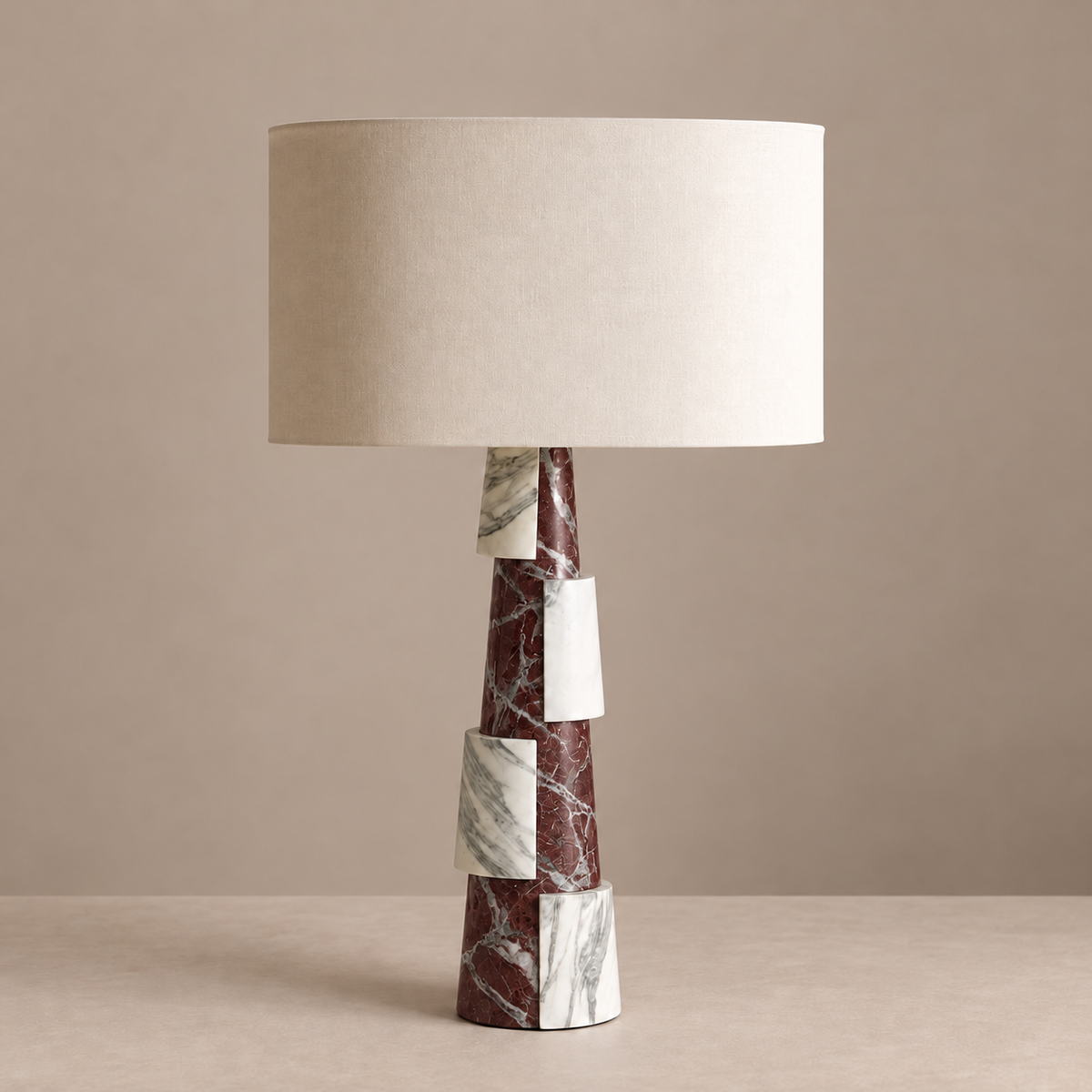 Burgundy and white marble table lamp with a natural linen drum shade, unlit.