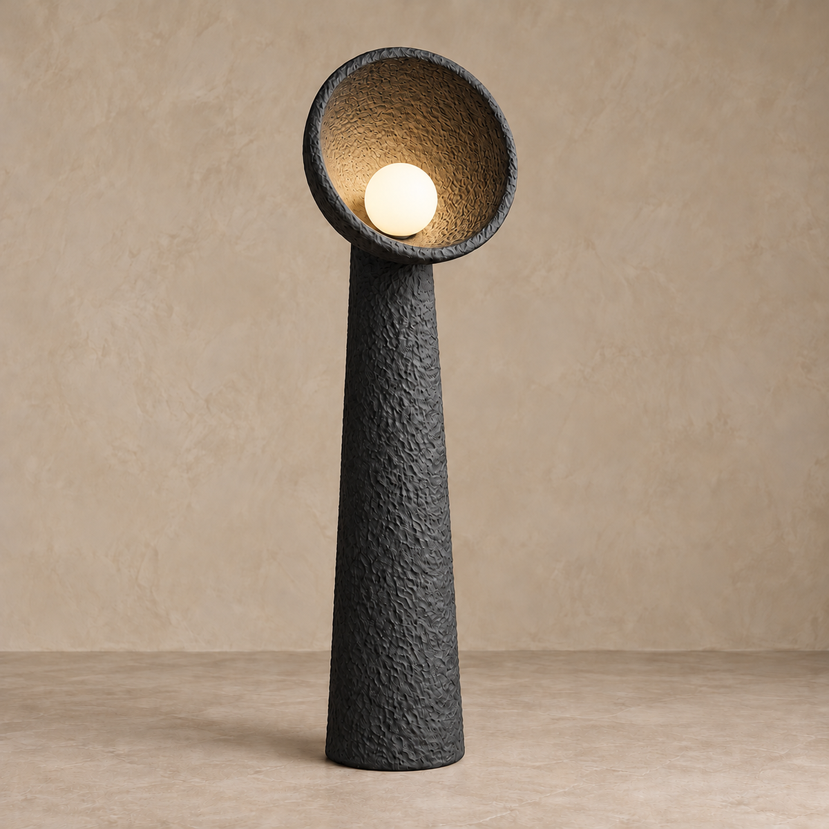 Large black Calla plaster lamp with its globe bulb illuminating the rough bowl.
