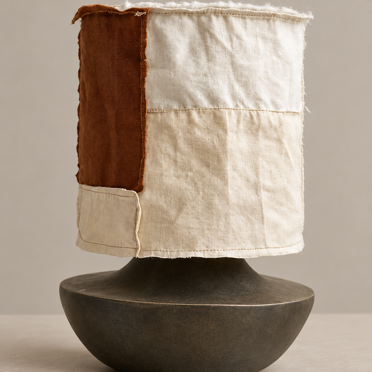 Close view of the patchwork fabric shade and dark ceramic base.
