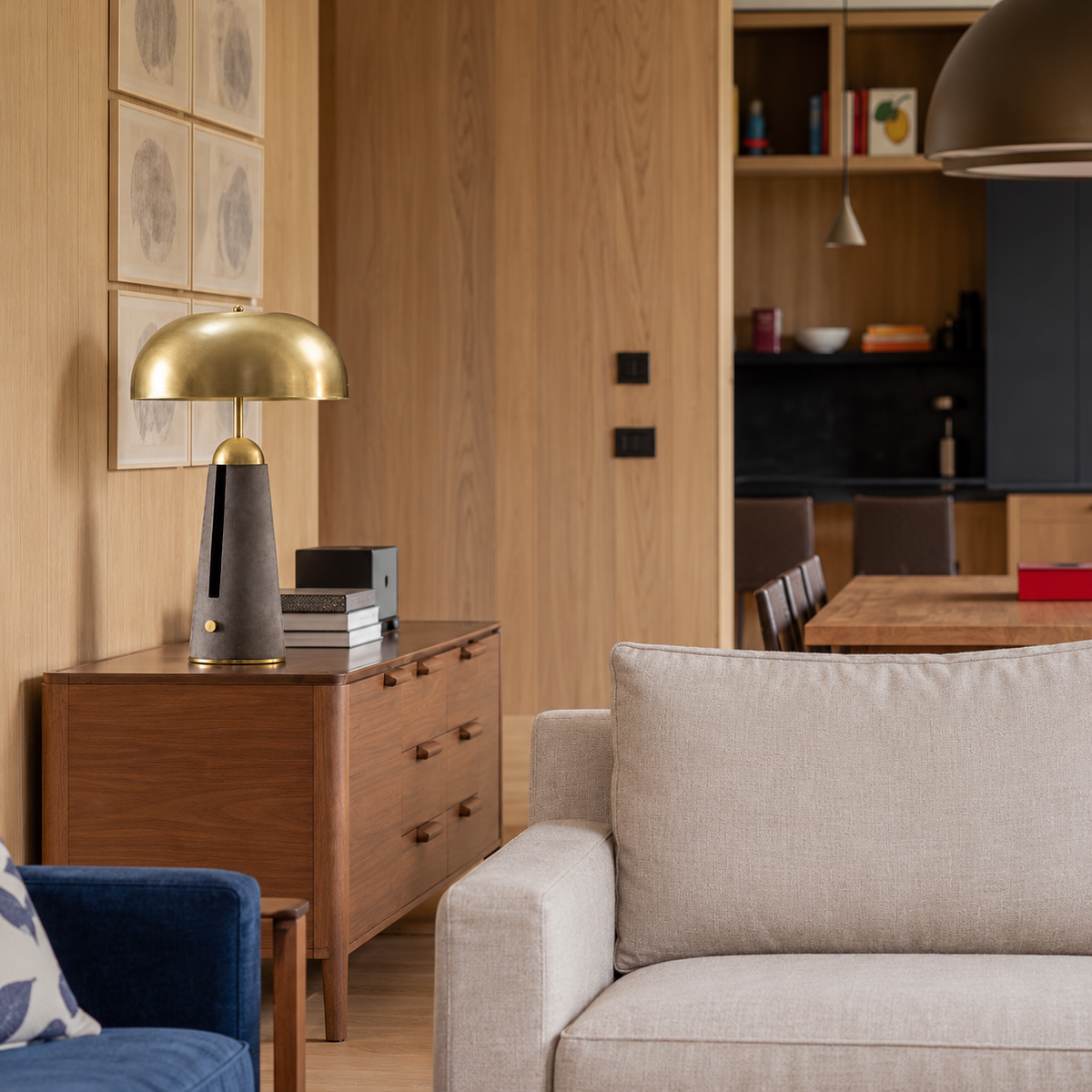 Brass dome table lamp with a charcoal leather base, placed in a living room setting