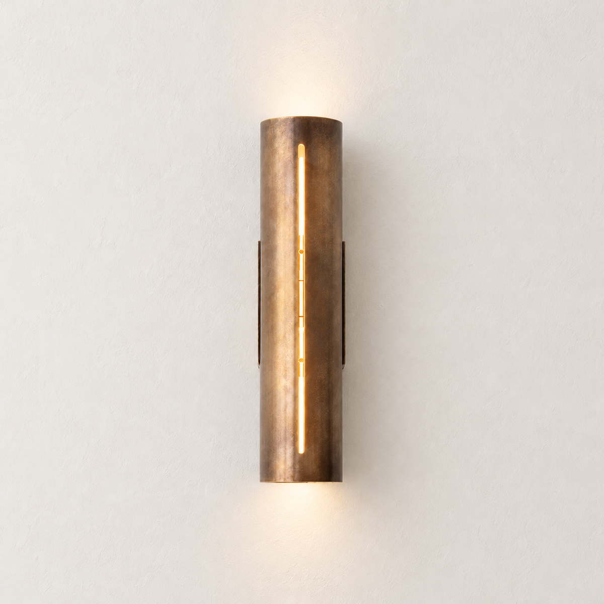Copper cylinder wall light with warm light visible through its vertical slit.
