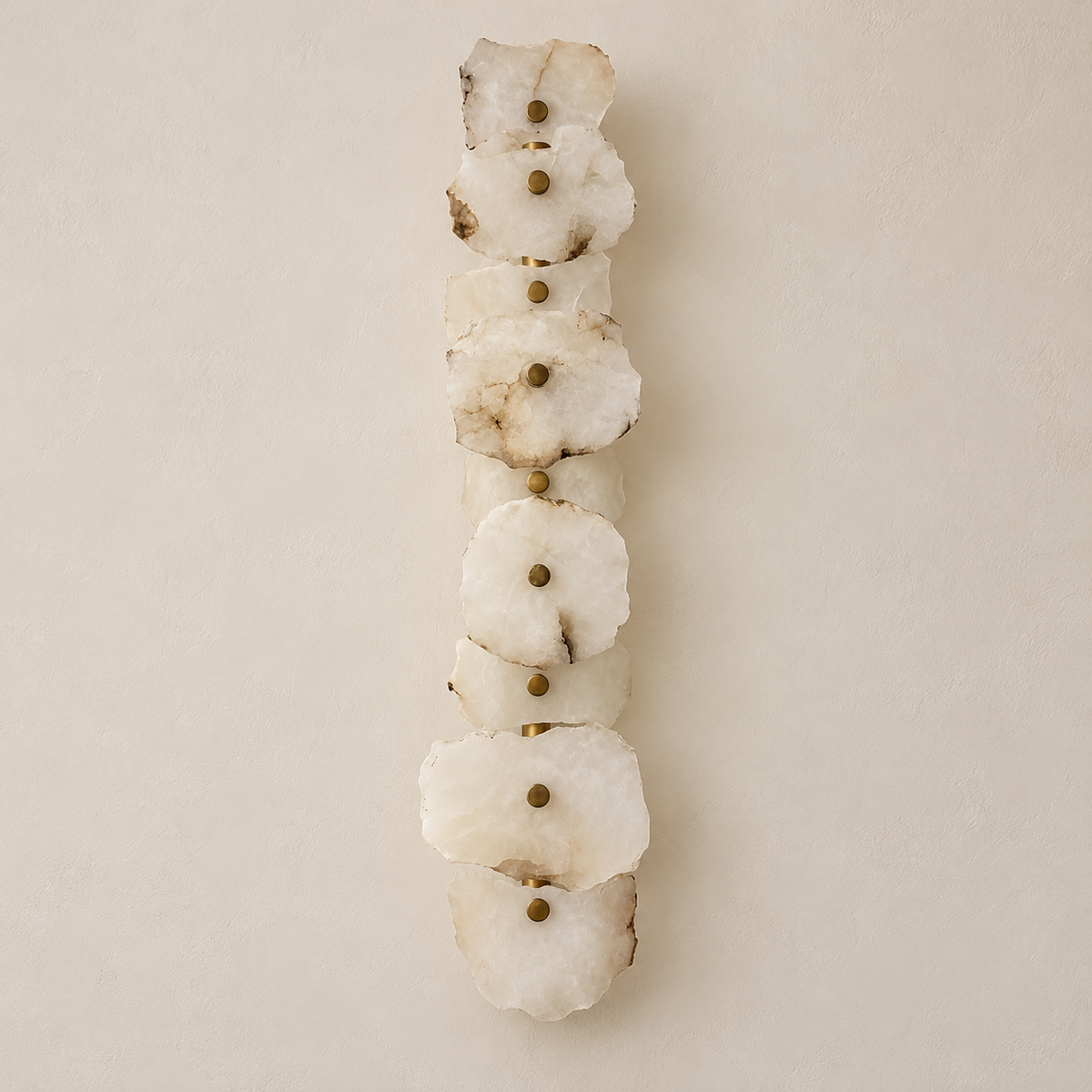 Unlit 9-stone marble wall sconce with irregular layered panels and brass retaining caps.