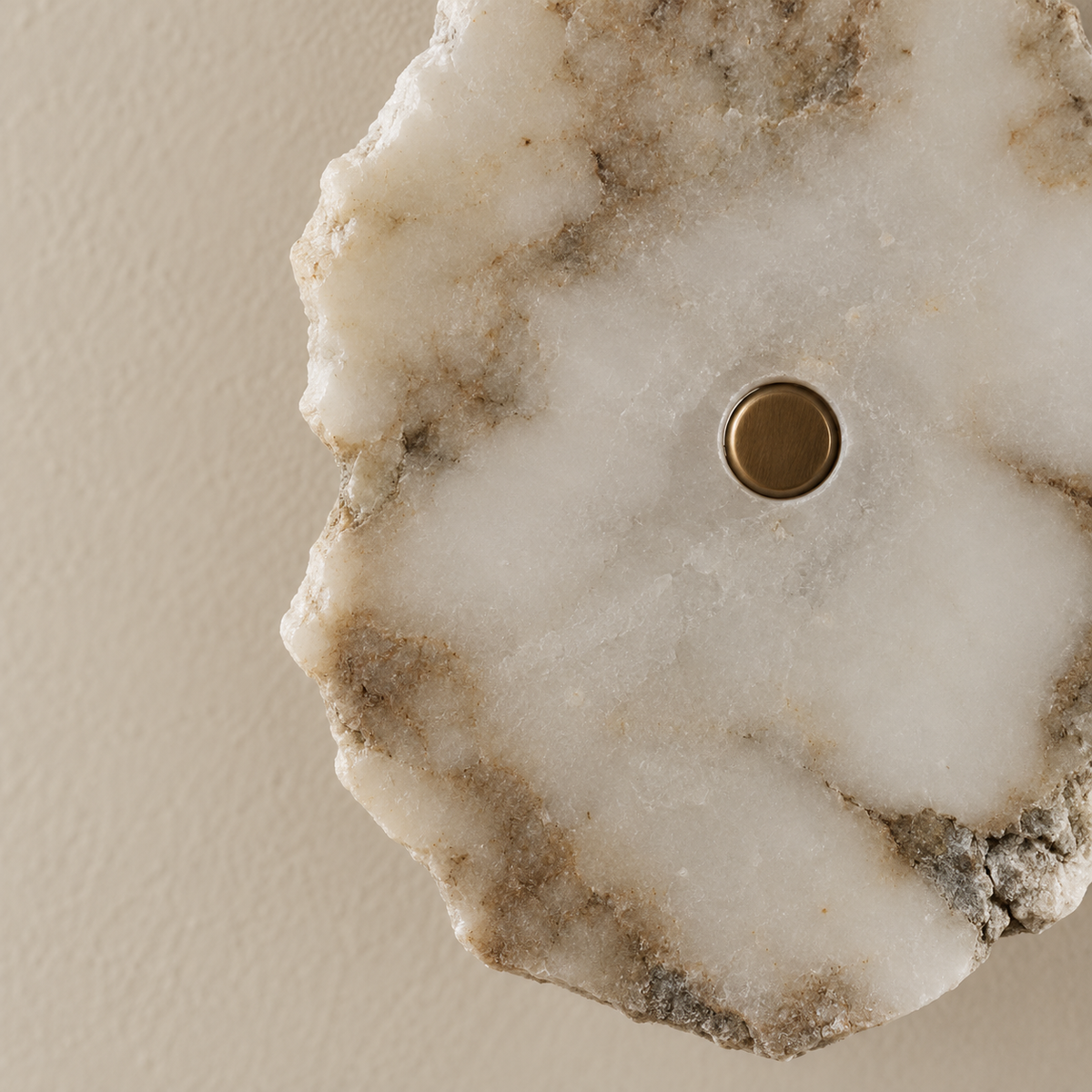 Close-up of the marble sconce’s rough natural edge, mineral markings and brass retaining cap.