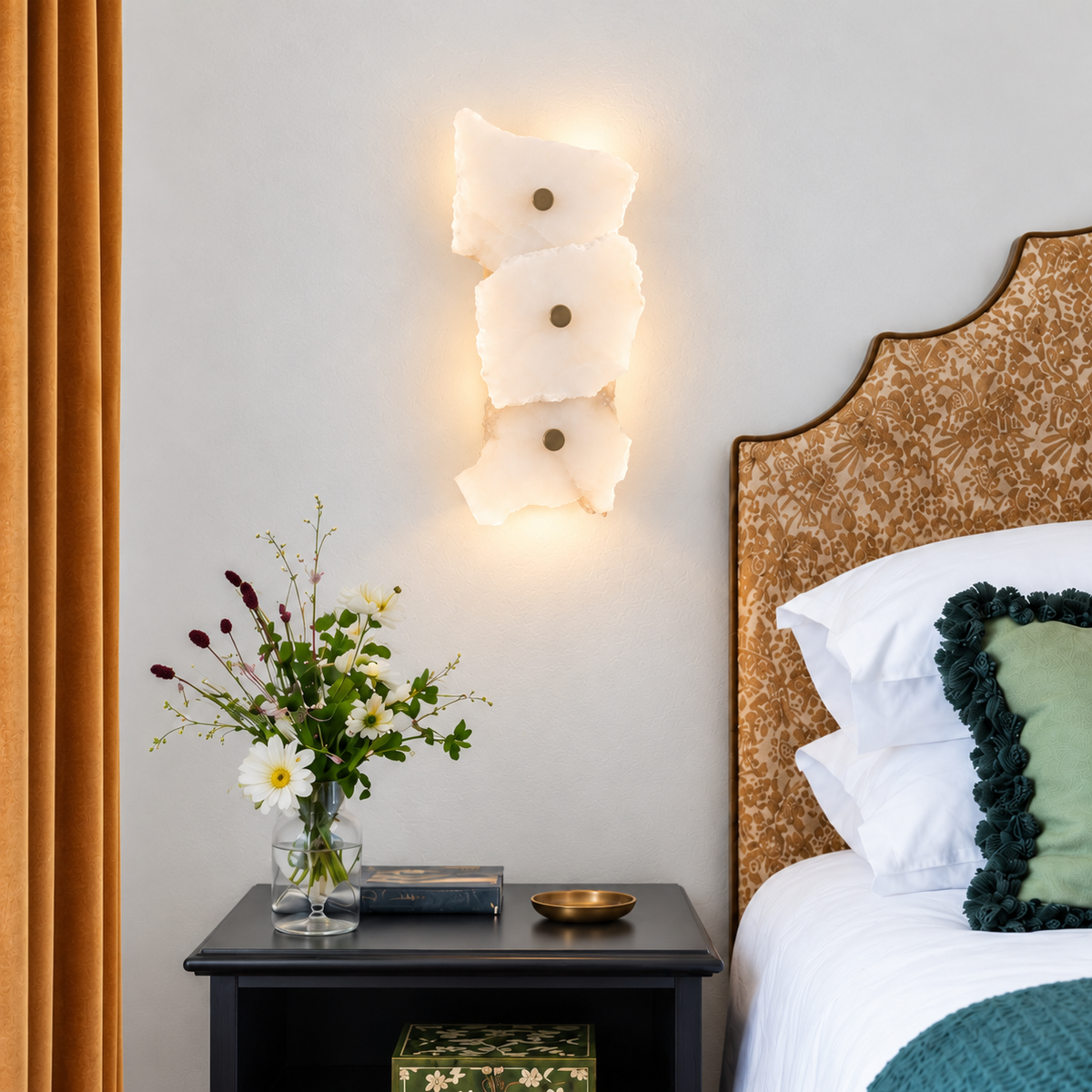 Three-stone marble wall sconce installed above an antique bedside chest in a naturally lit bedroom.