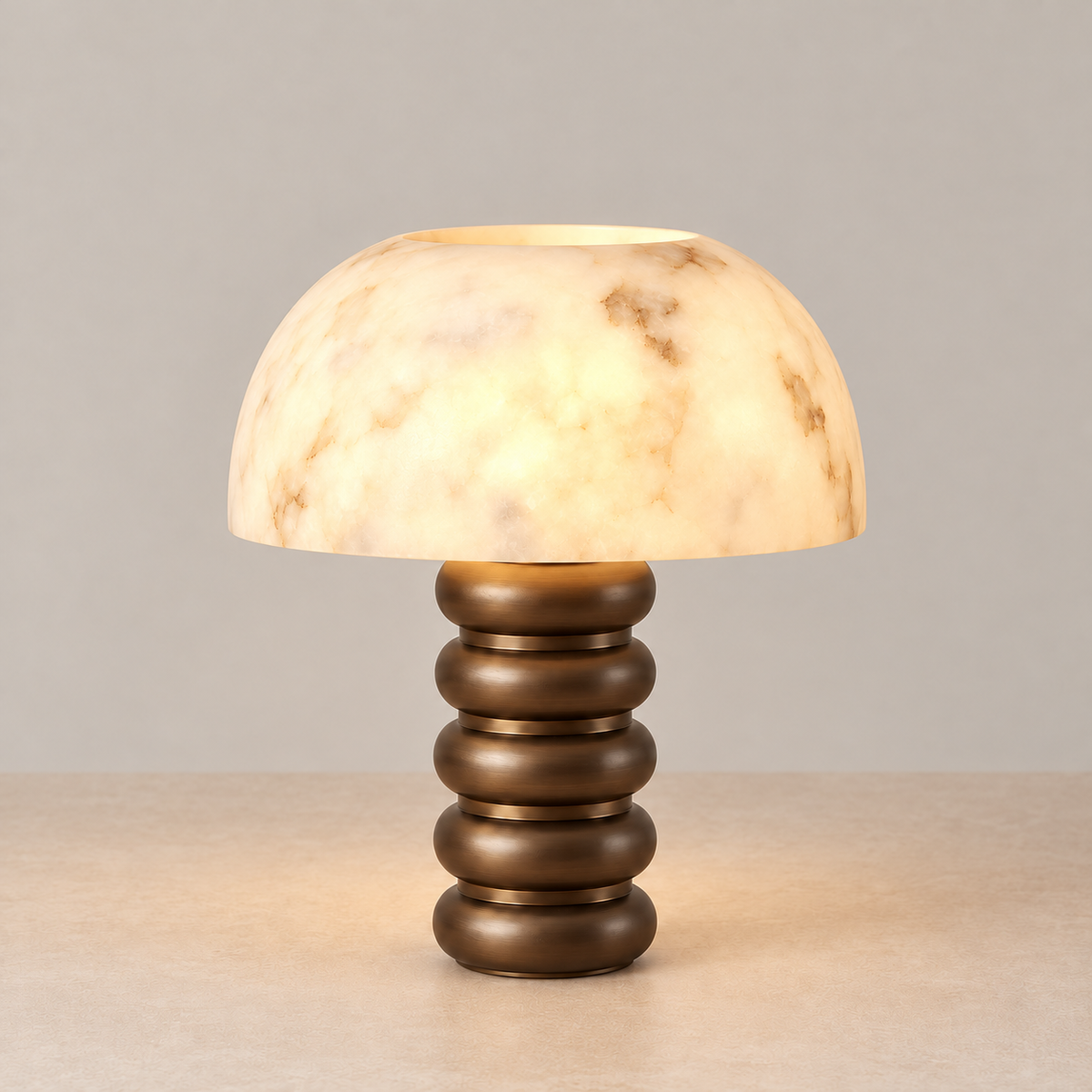 Illuminated alabaster dome table lamp with tiered bronze base.