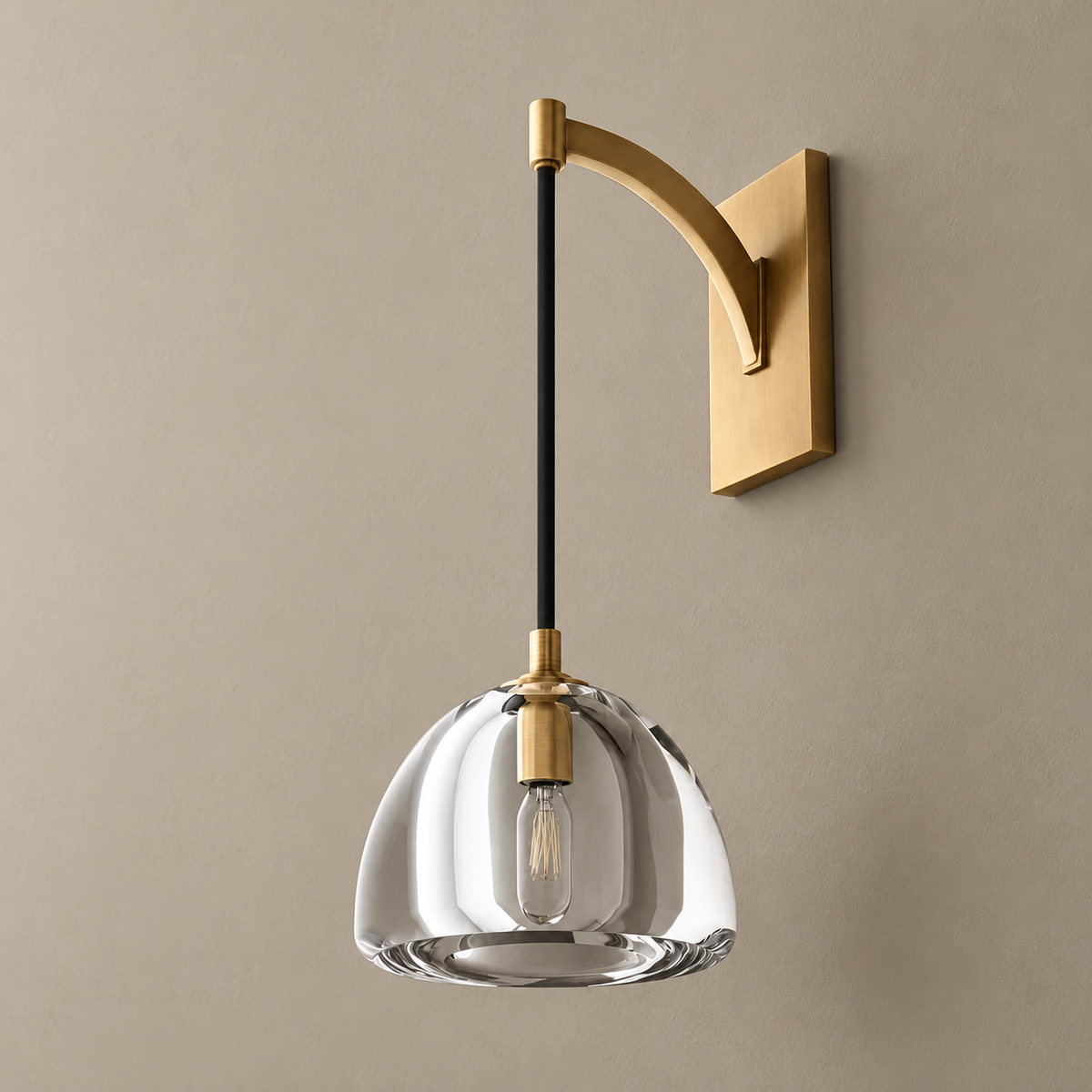 Clear glass dome and metal arm wall sconce, unlit on a stone-beige wall