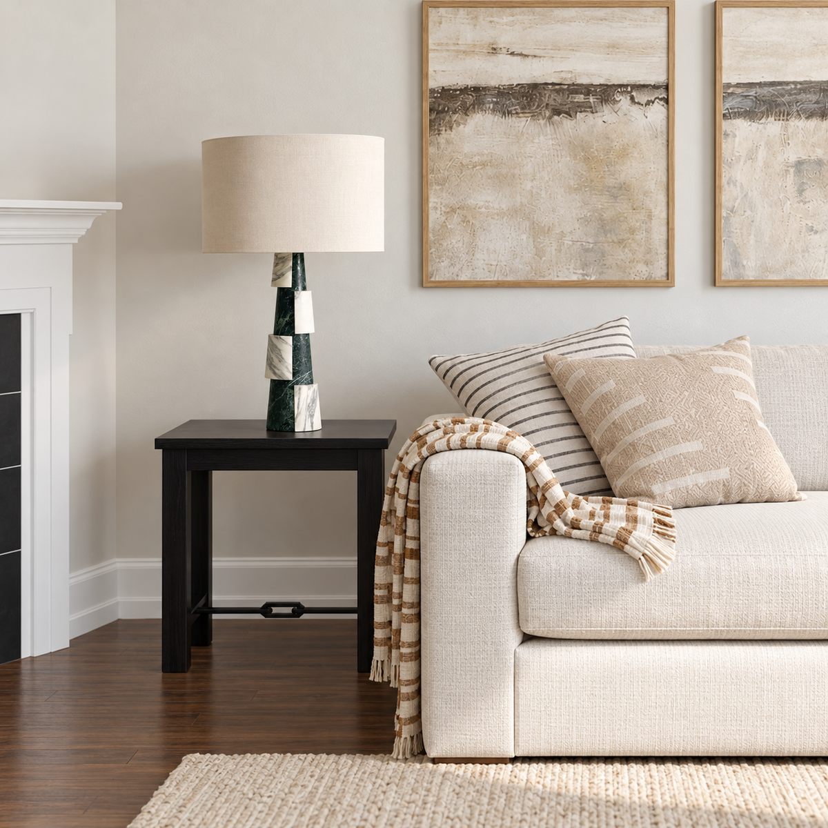 Green marble table lamp on a black side table beside a cream sofa.
