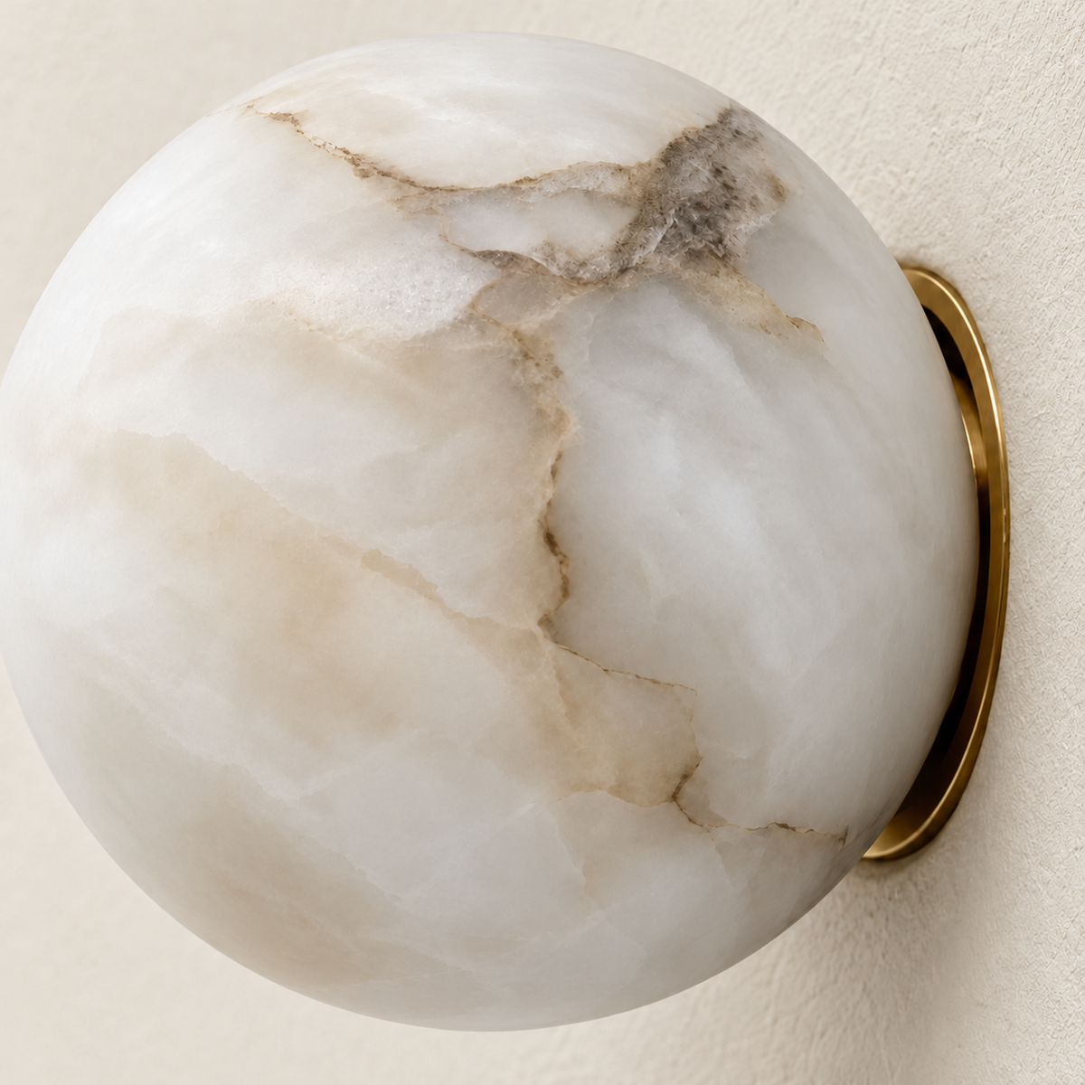 Close-up of natural alabaster veining and the slim brass backplate on the globe wall sconce.