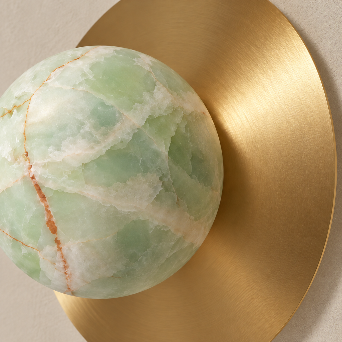 Close detail of green onyx mineral bands beside the brushed brass disc.