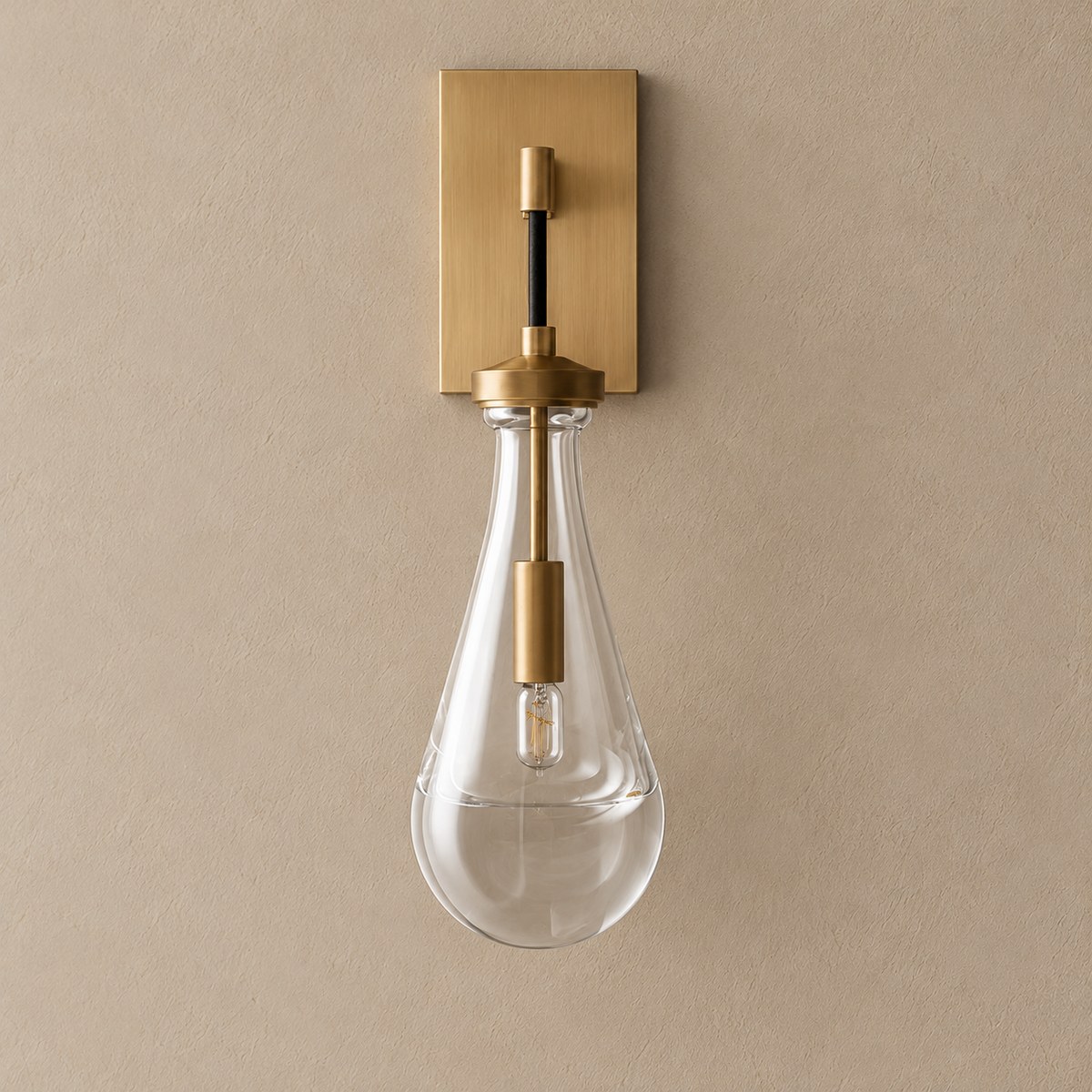 Front view of the Raindrop sconce, showing its teardrop glass and rectangular brass backplate.