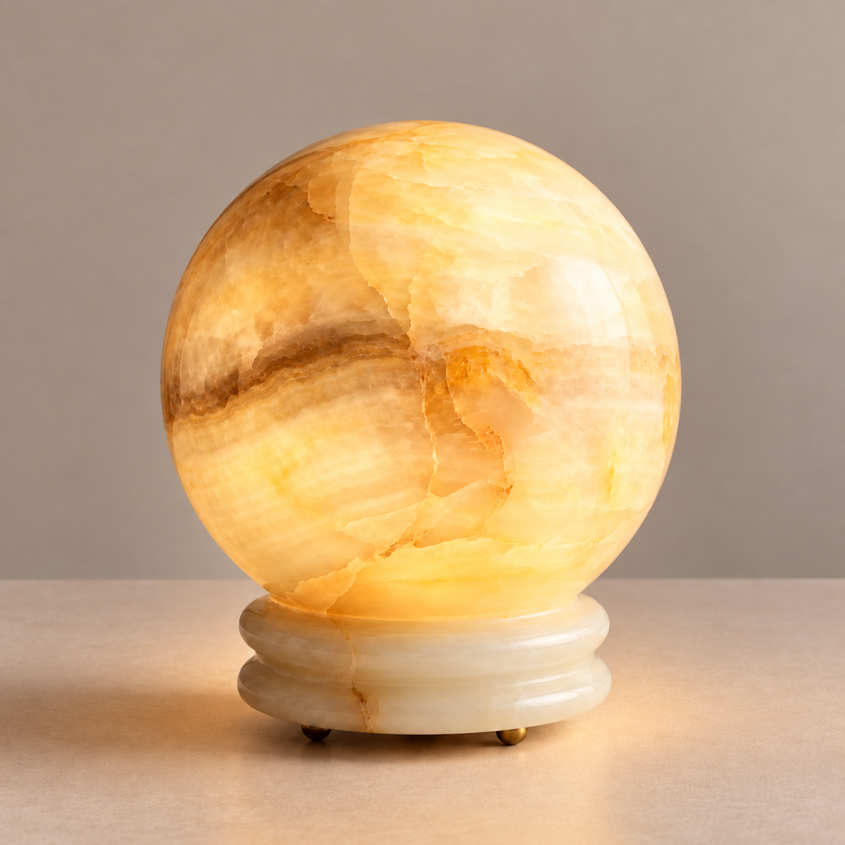 Onyx globe table lamp illuminated, showing natural cream and honey bands