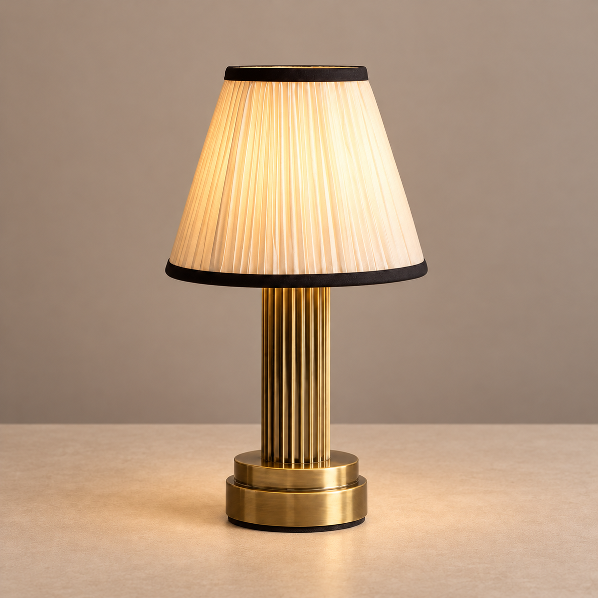 Brass table lamp with its pleated fabric shade illuminated