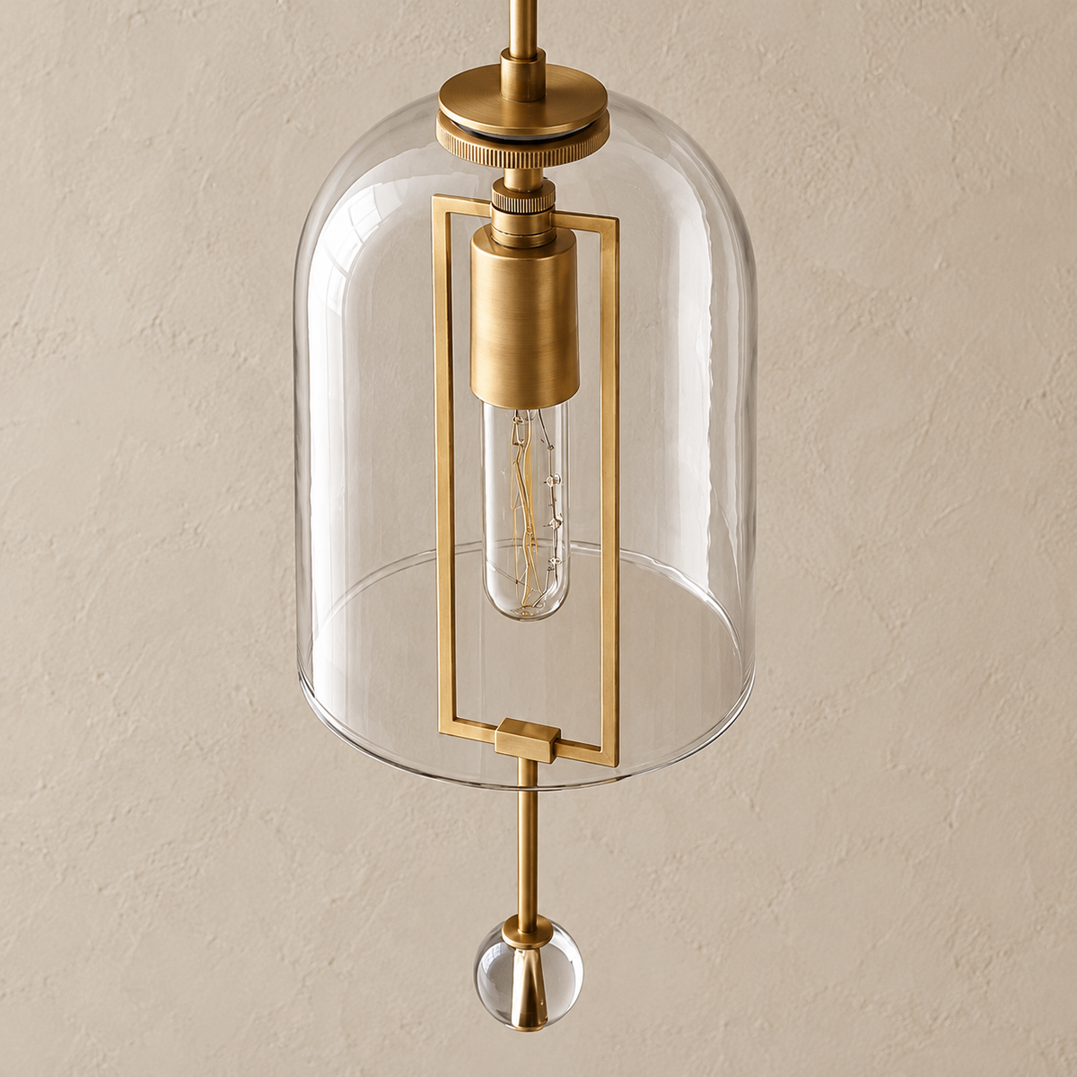 Close-up of the clear glass bell, brass frame and lower crystal finial.