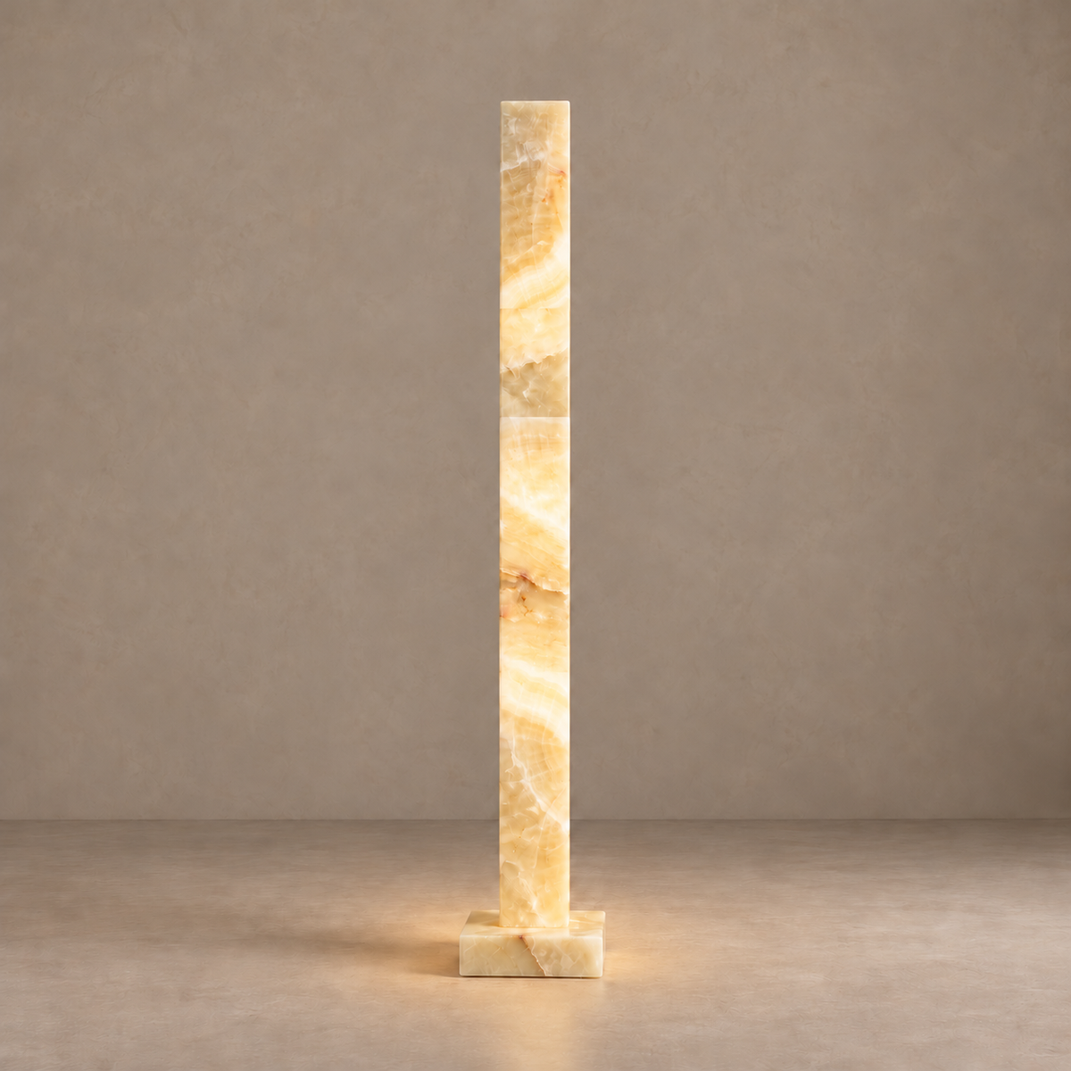 Large honey onyx column lamp illuminated through its natural mineral layers.