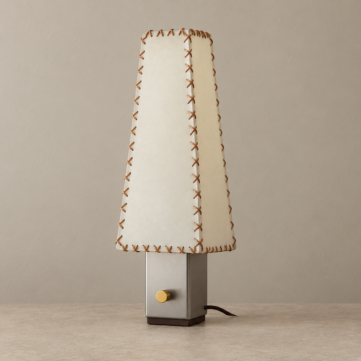 Unlit stitched parchment table lamp on a beige background.