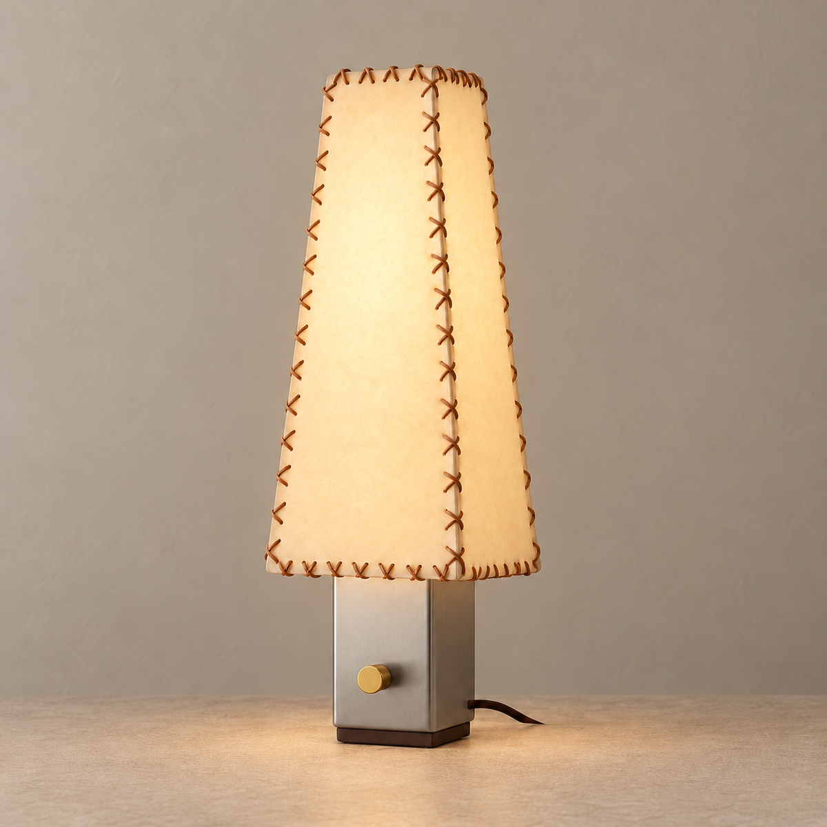 Stitched parchment shade illuminated above a steel base.
