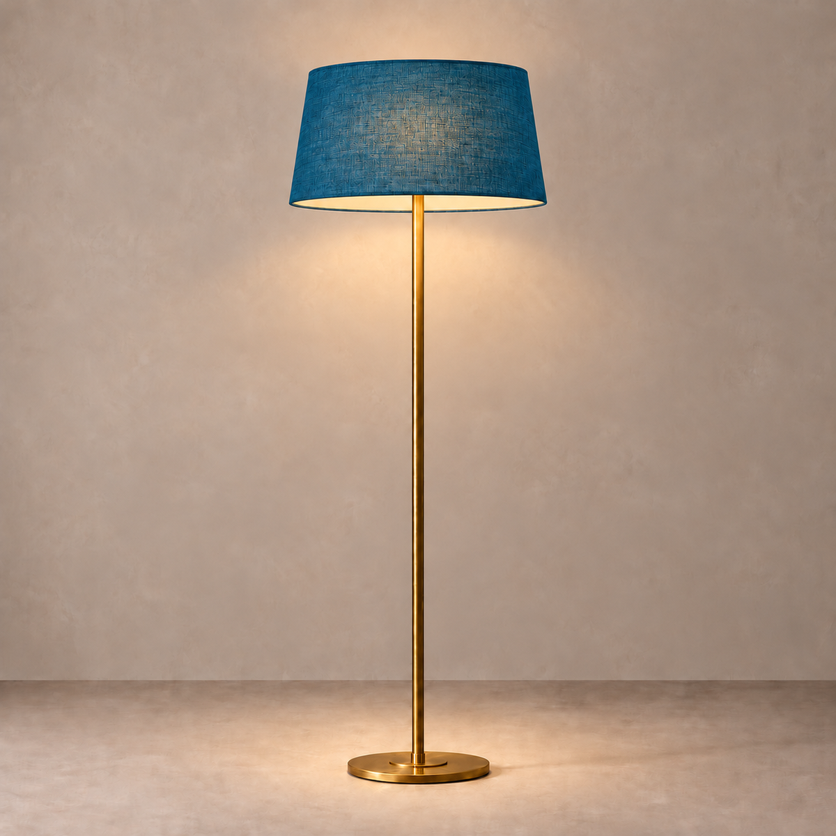 Brushed Brass Floor Lamp with petrol blue linen shade, illuminated in natural daylight.