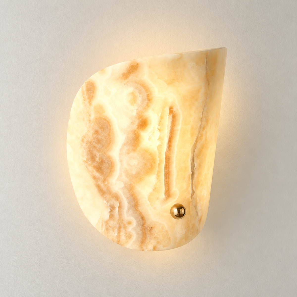 Jade curved wall sconce illuminated on warm ivory.