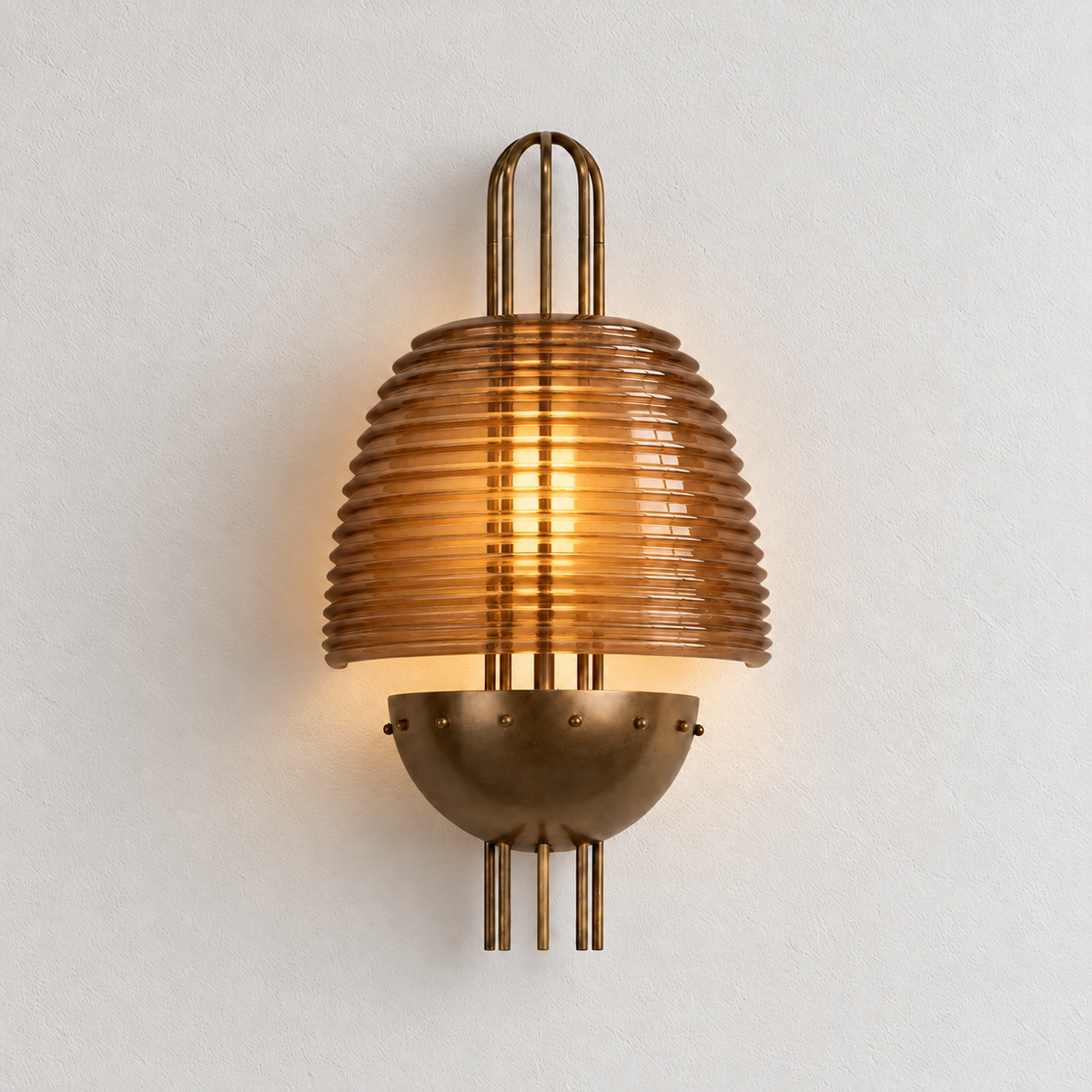 The same Cassian amber glass wall sconce illuminated on ivory plaster.