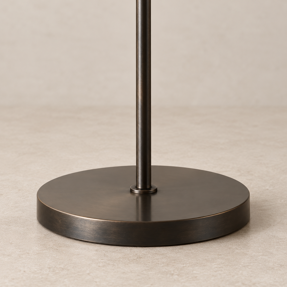 Round dark copper base and slim straight stem of the Trieste floor lamp.