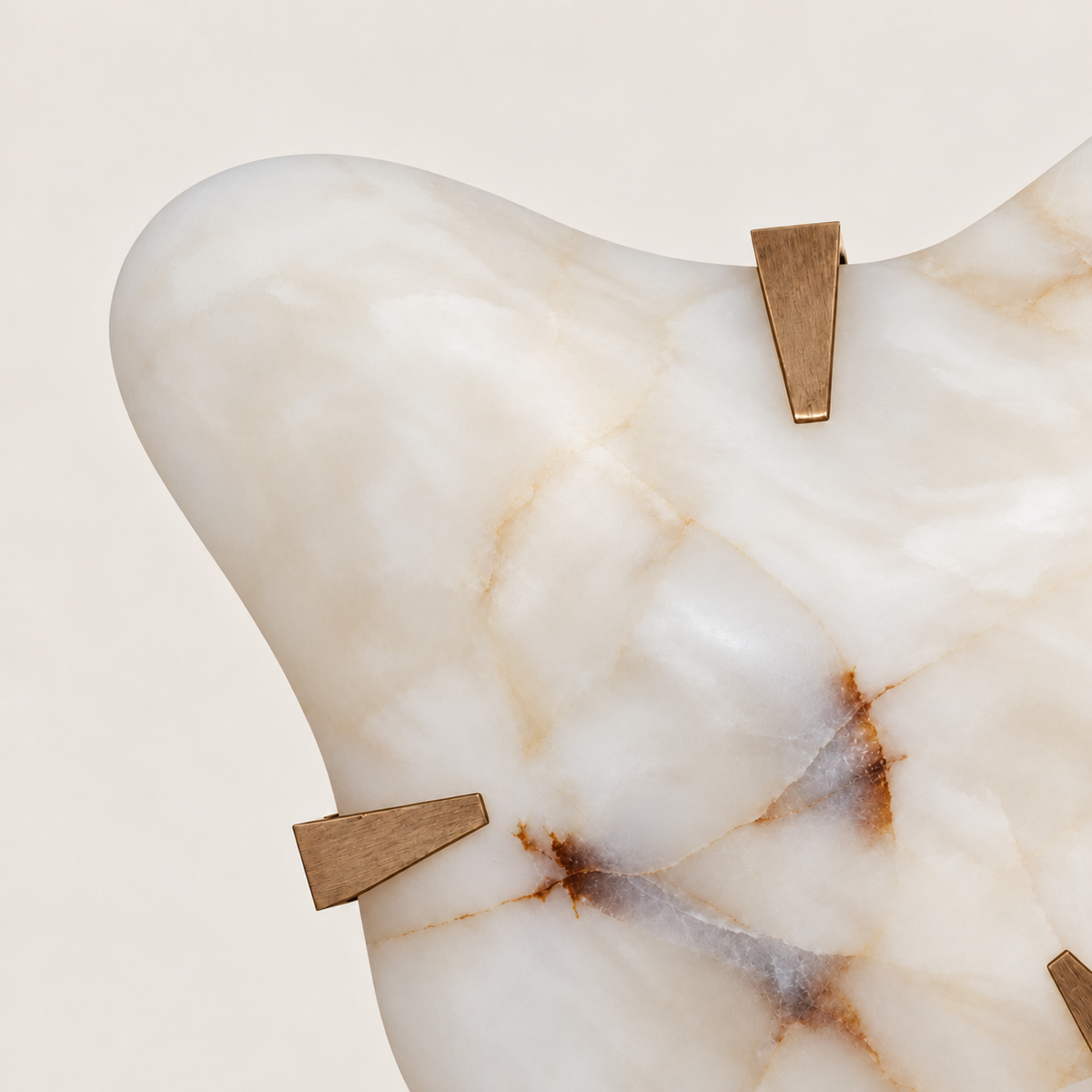 Close-up of an angular brass clip and the natural veining of the alabaster cloud.