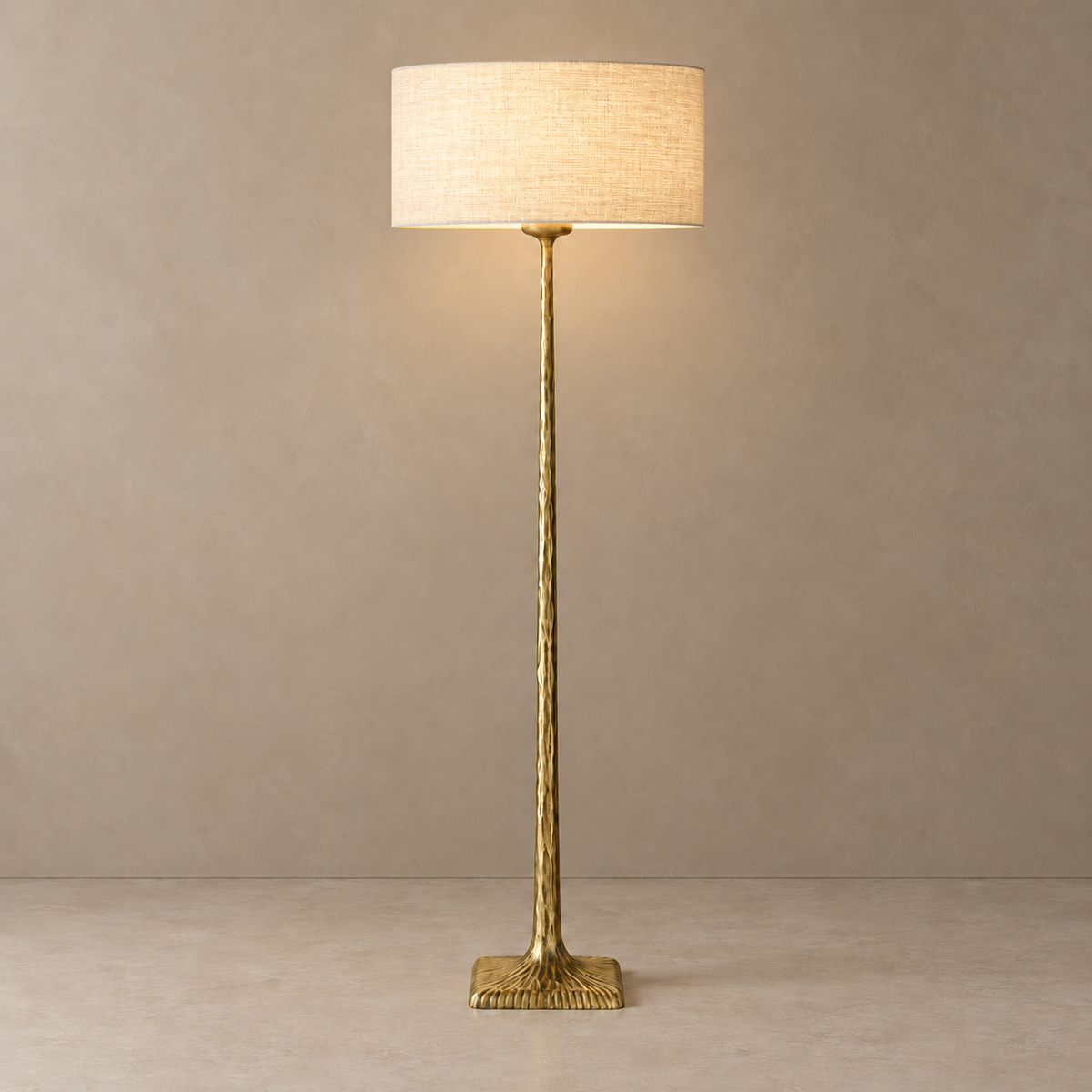 CLVGTPO1 floor lamp illuminated through its linen shade, with the patinated brass stem and base visible.