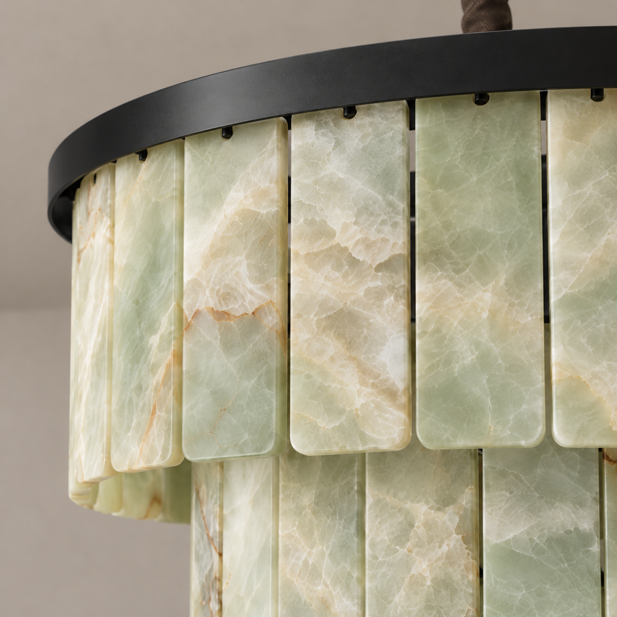Close view of green onyx panels and black rim on the tiered chandelier.