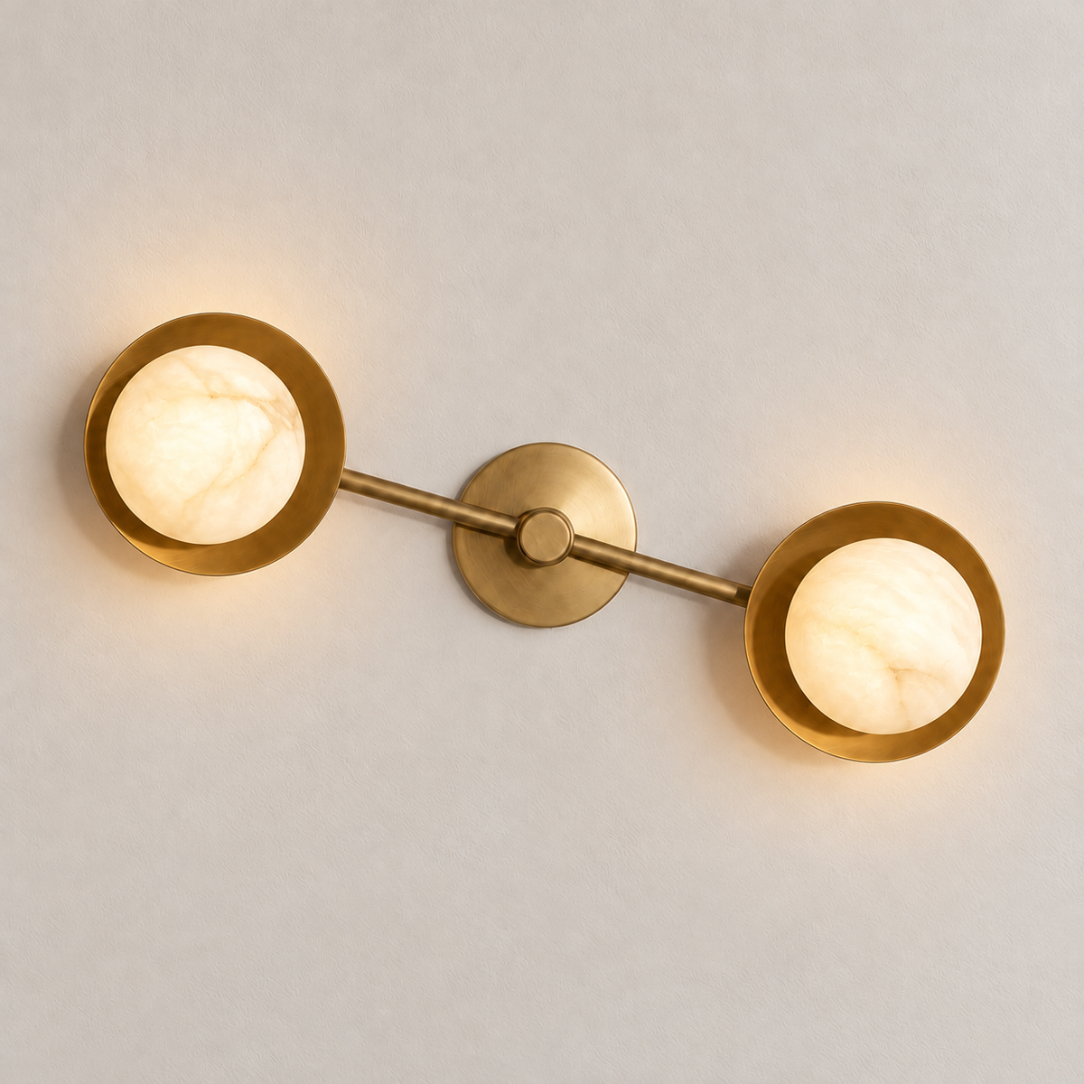 The two alabaster globes glow warmly in the brass double wall sconce.