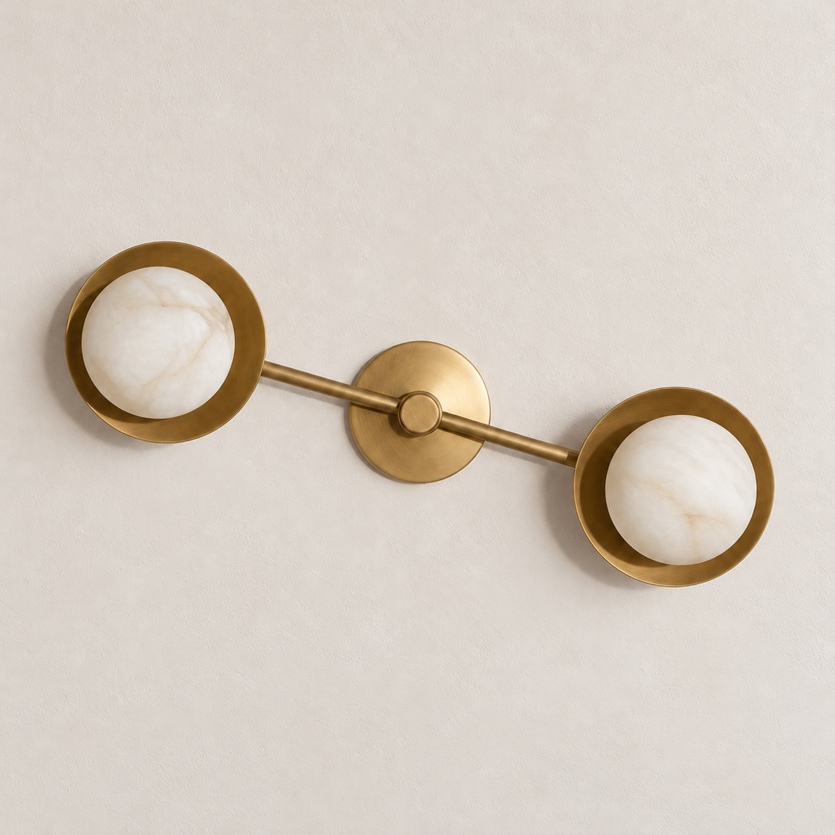Unlit double alabaster globe wall sconce with brass discs and a diagonal connecting bar.