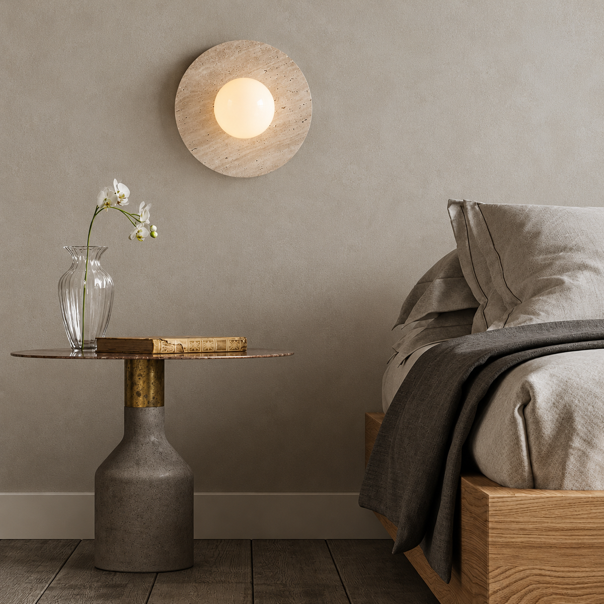 Round beige stone wall light with a central opal globe mounted on the bedroom wall above a pedestal bedside table.