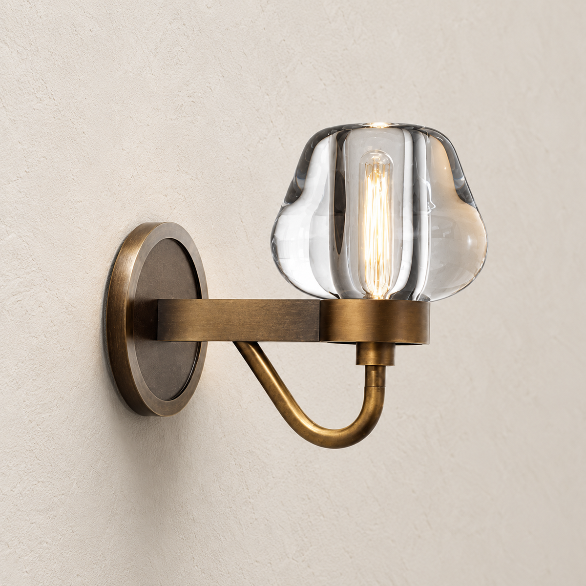 Side view of the crystal wall sconce with its brass arm and curved support.