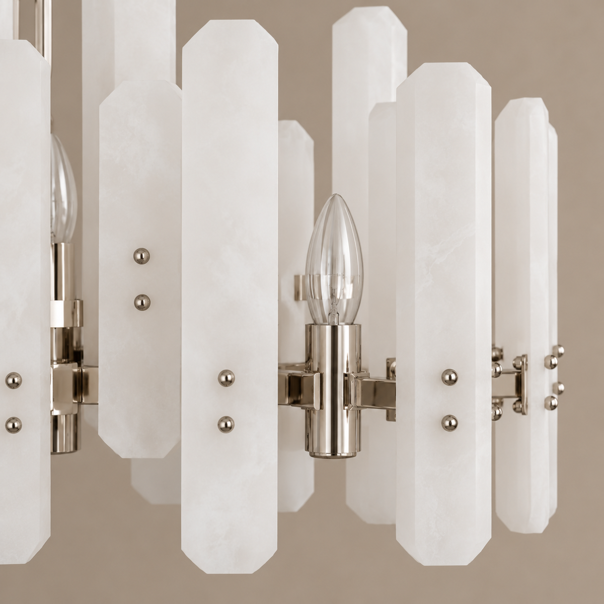 Detail of the chandelier's clipped-corner frosted-glass panels, silver fittings and candle bulb.